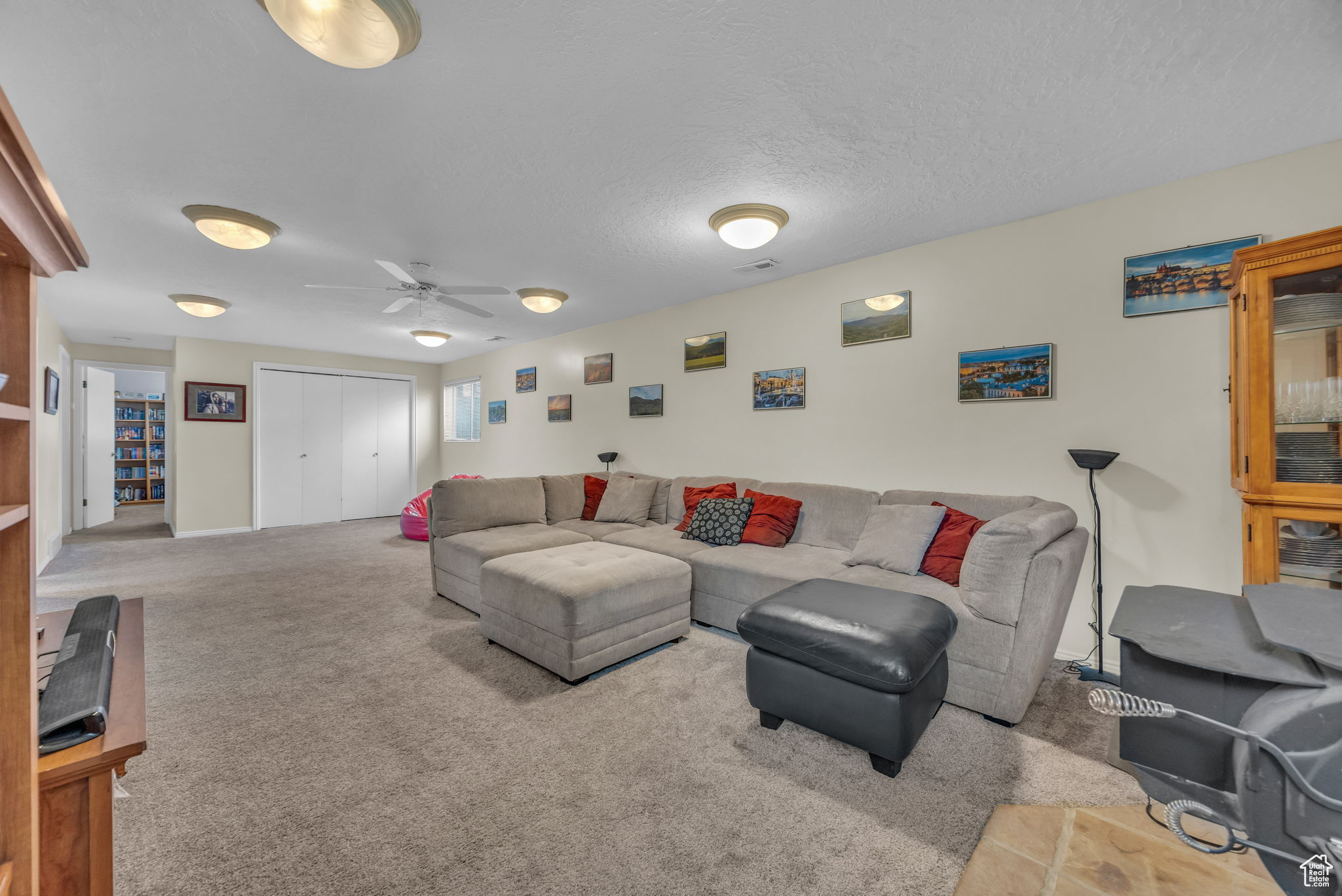 Carpeted living room featuring a textured ceiling and ceiling fan