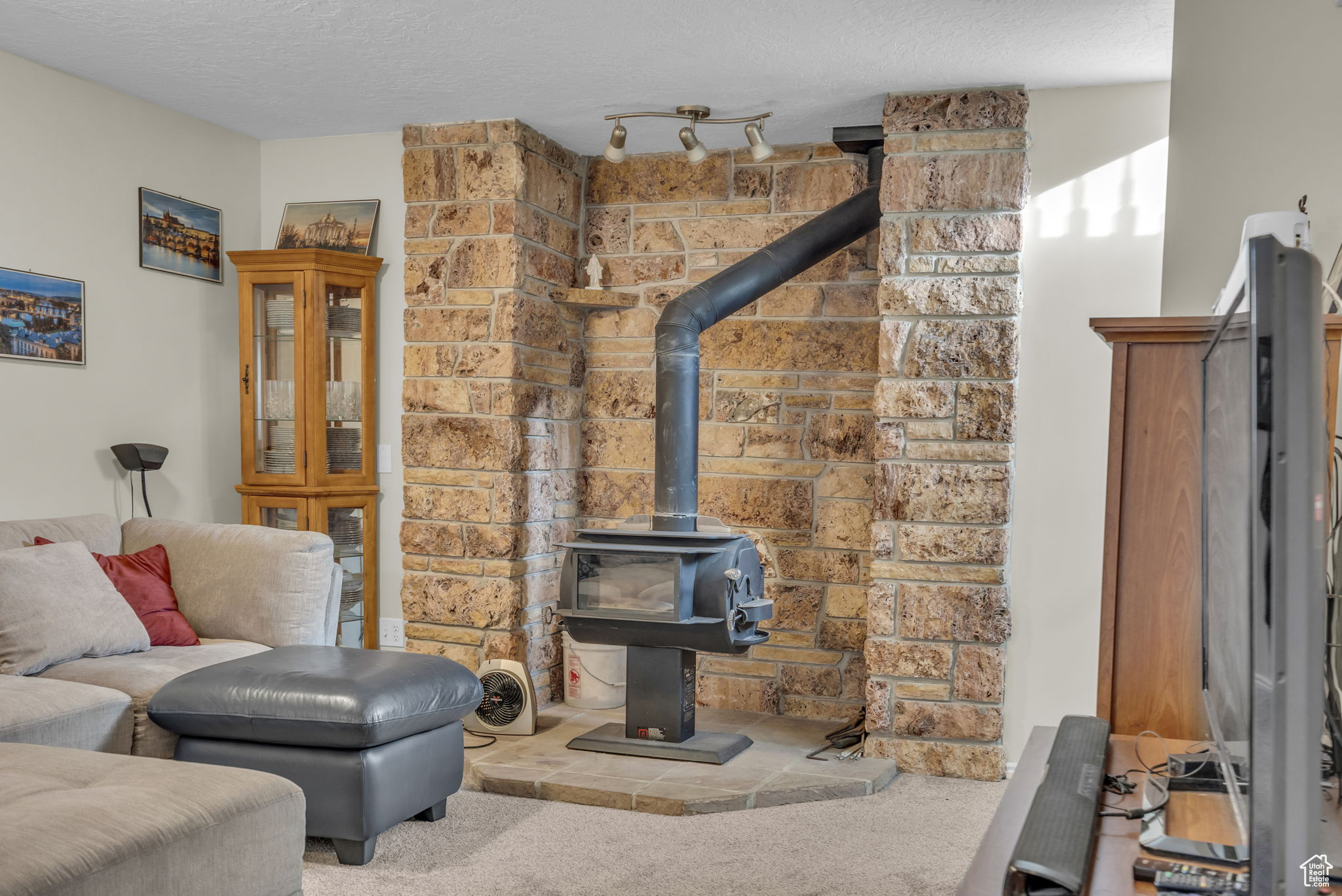 Workout room with carpet, a wood stove, and a textured ceiling