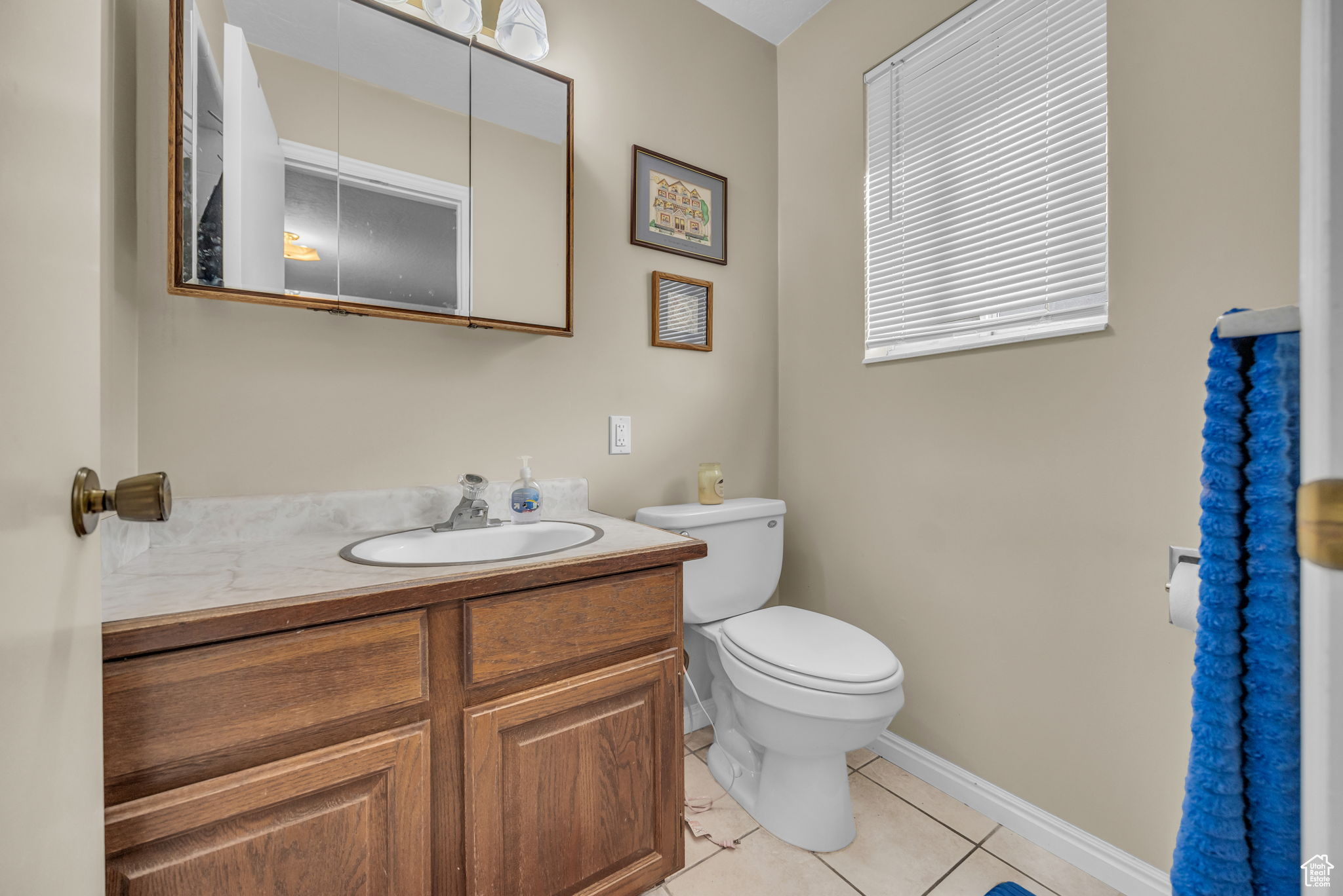 Bathroom with toilet, vanity, and tile patterned floors