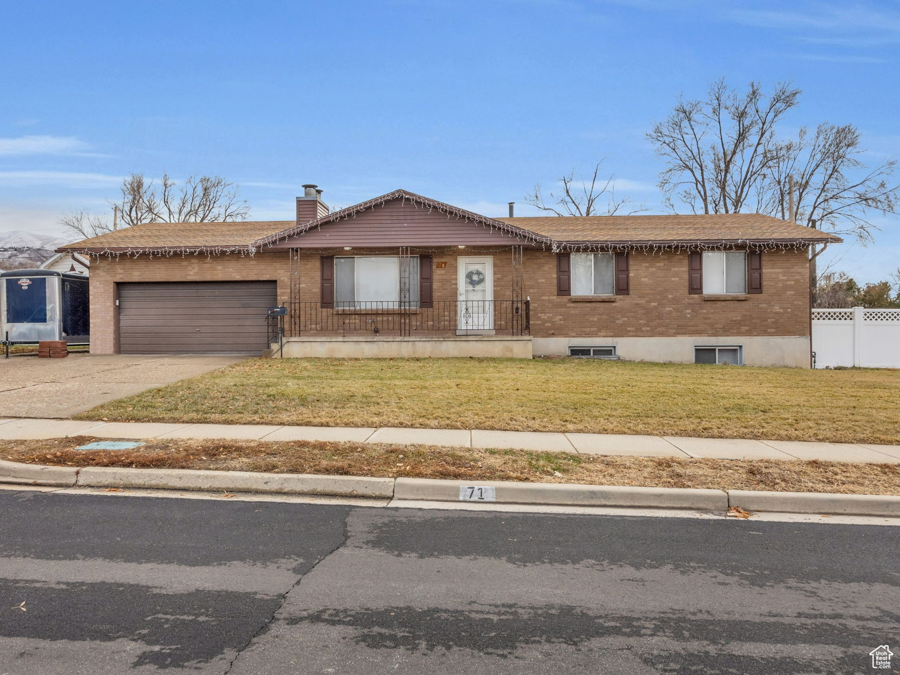 Single story home with a garage and a front lawn