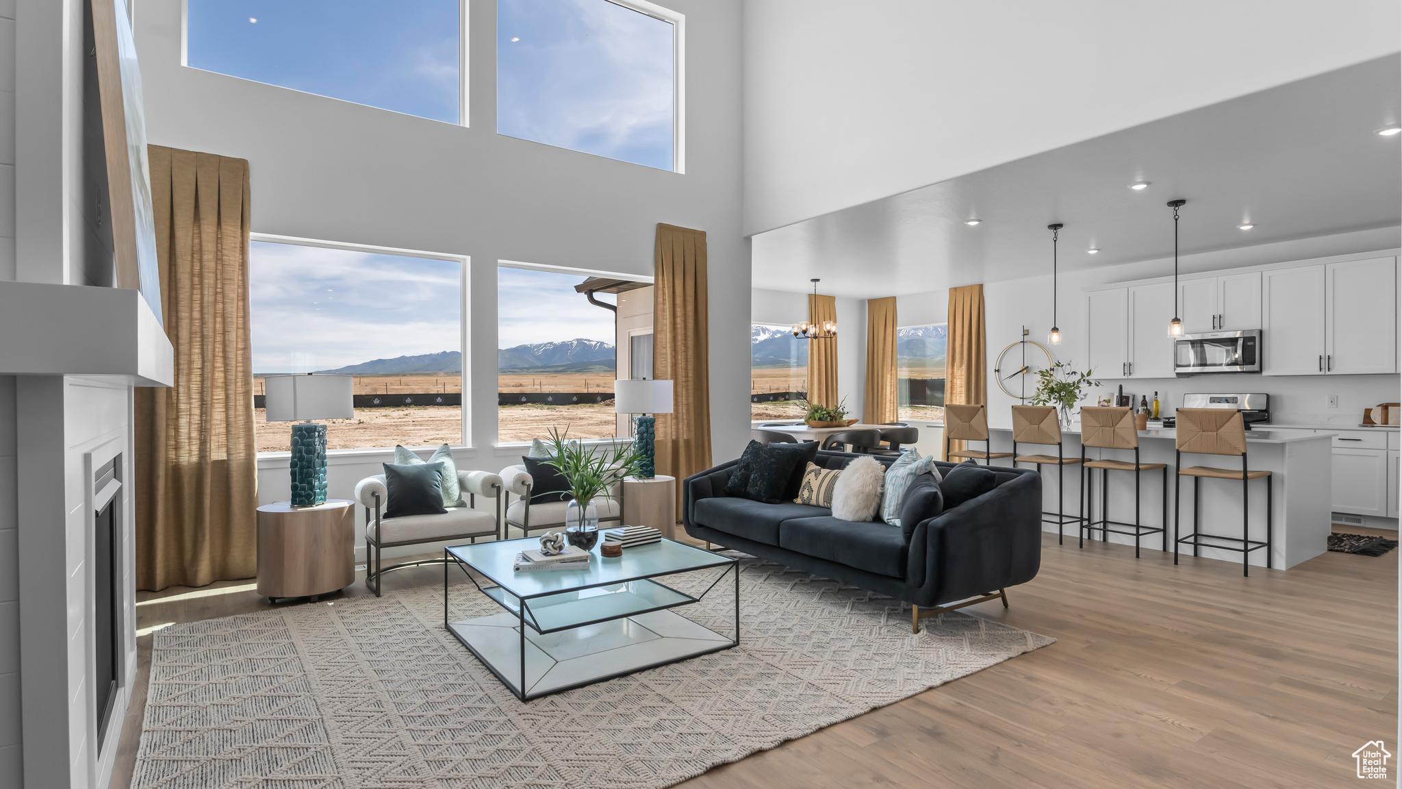 Living room with a mountain view, light hardwood / wood-style floors, plenty of natural light, and a chandelier