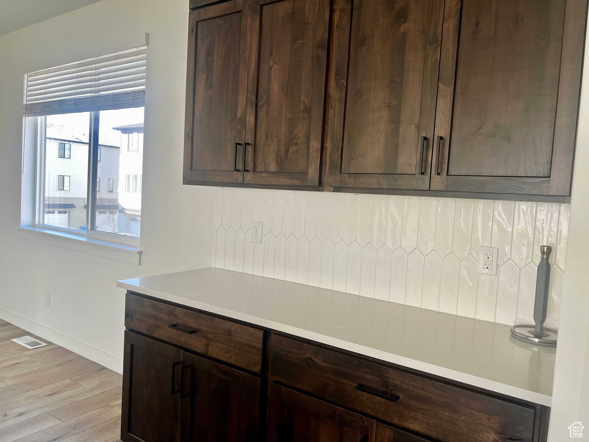 Kitchen with dark brown cabinetry and light wood-type flooring