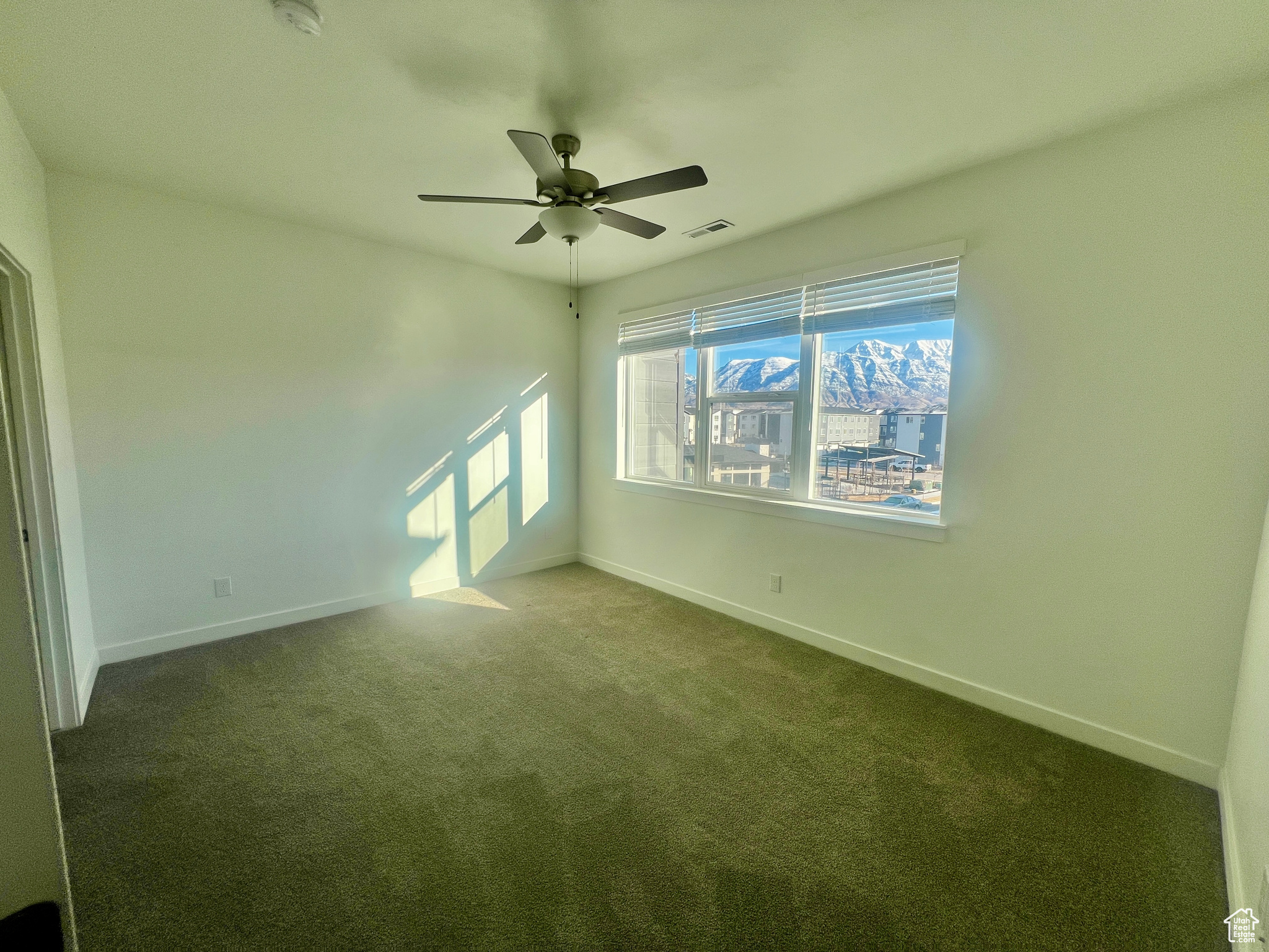 Carpeted empty room with ceiling fan