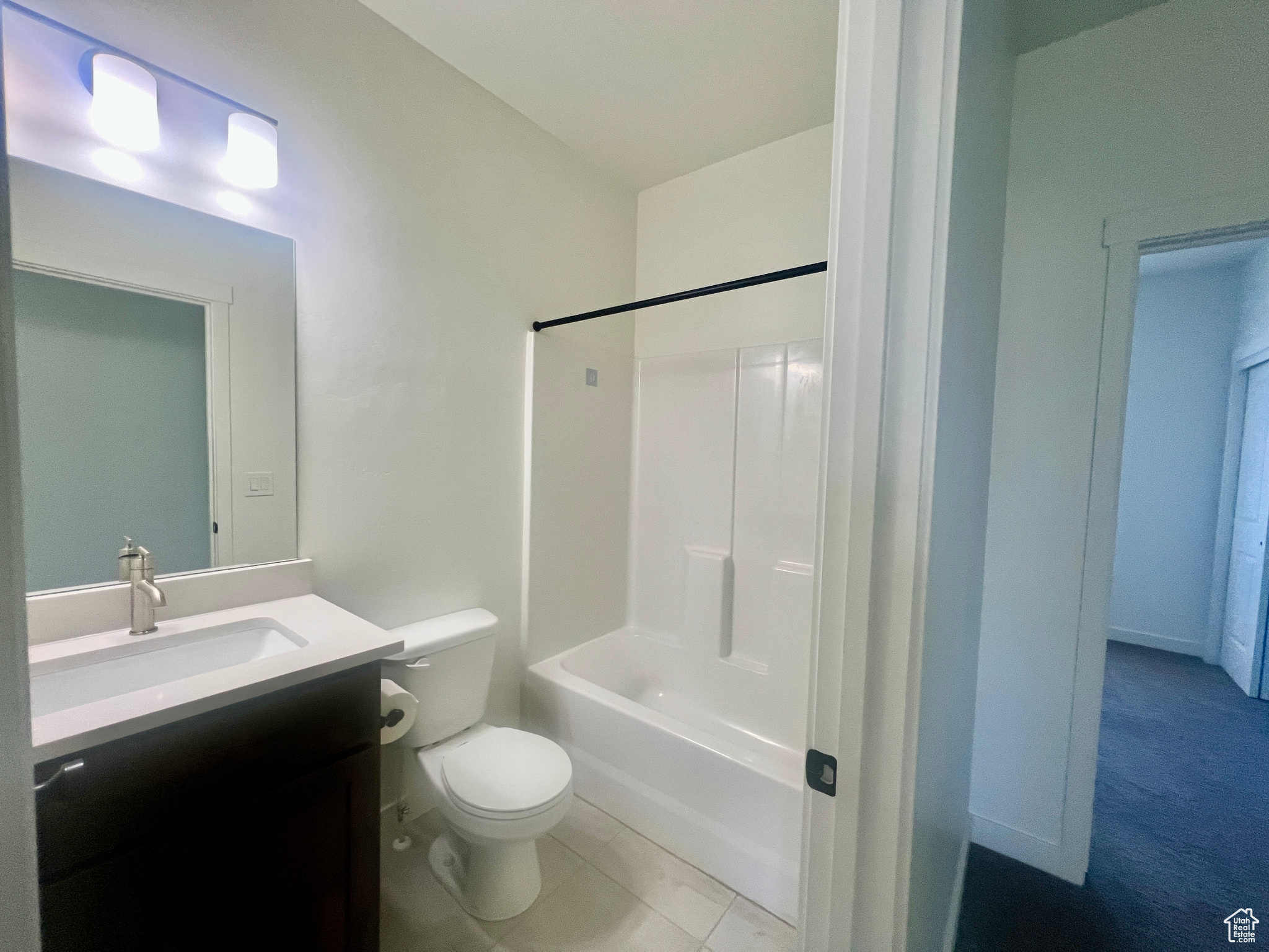 Full bathroom with tile patterned flooring, vanity, shower / bath combination, and toilet