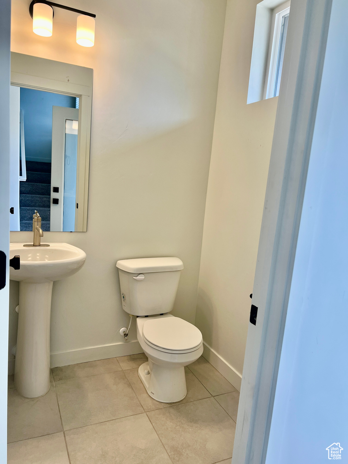 Bathroom featuring tile patterned floors, toilet, and sink