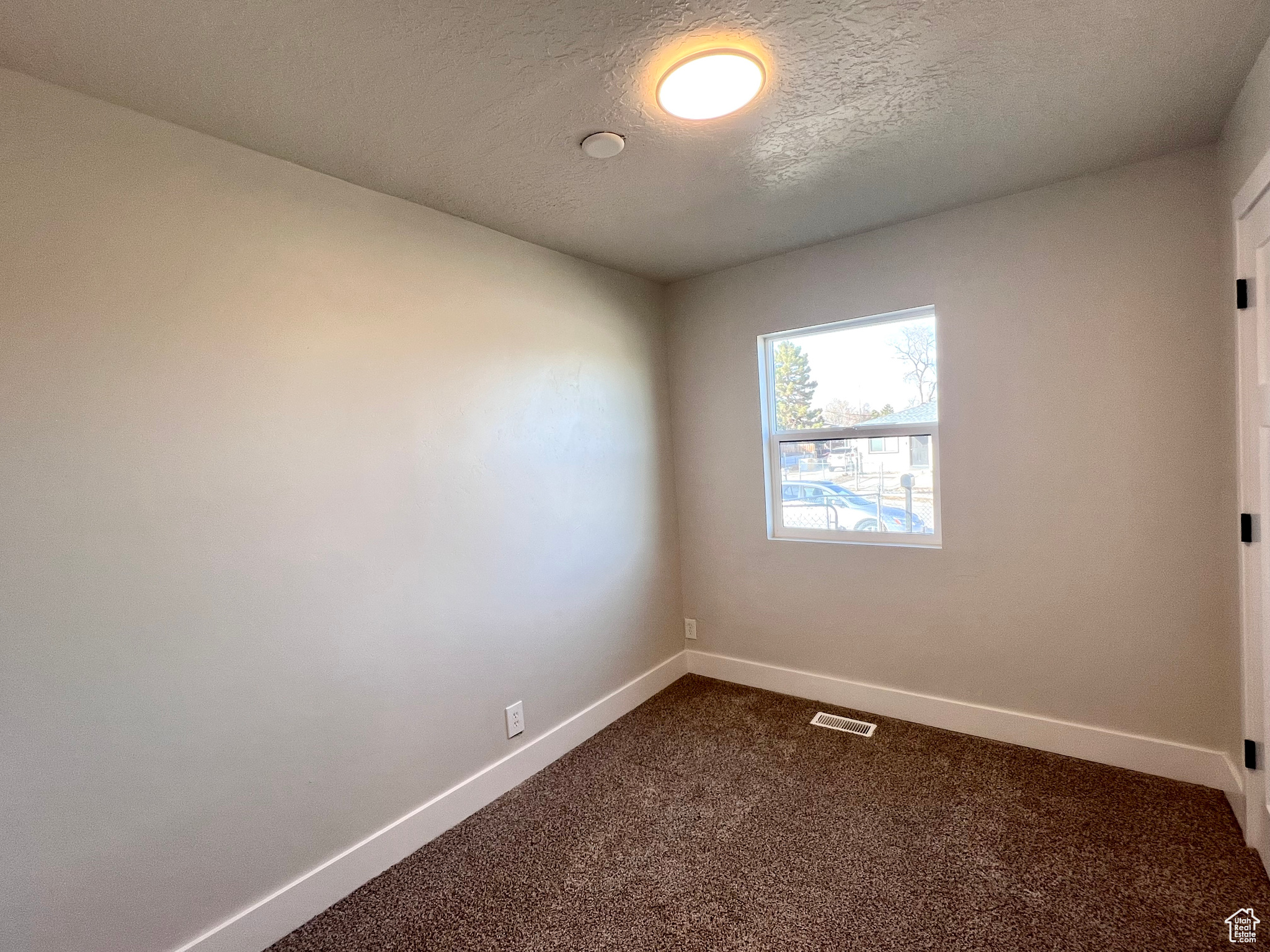 Spare room with carpet floors and a textured ceiling