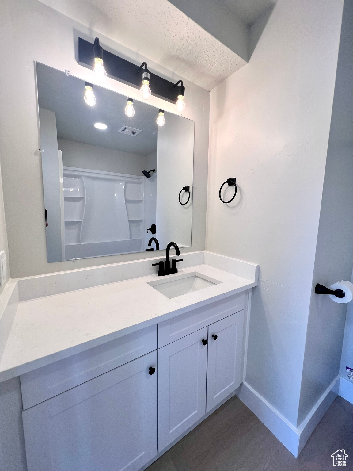 Bathroom featuring vanity, a shower, a textured ceiling, and hardwood / wood-style flooring