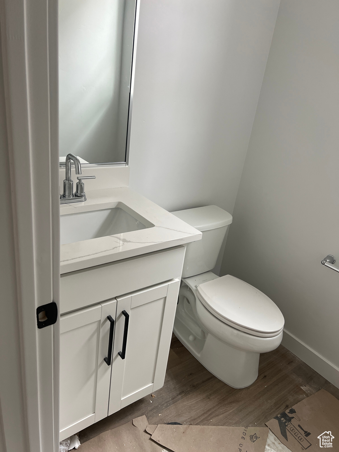 Bathroom with hardwood / wood-style floors, vanity, and toilet