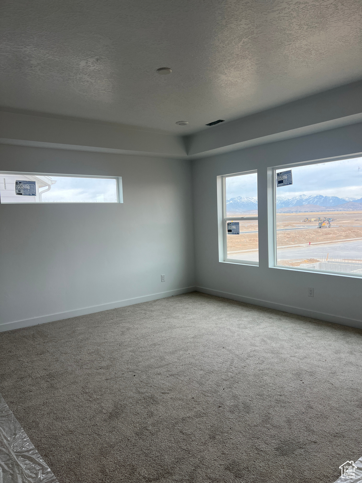 Empty room featuring carpet flooring and a textured ceiling