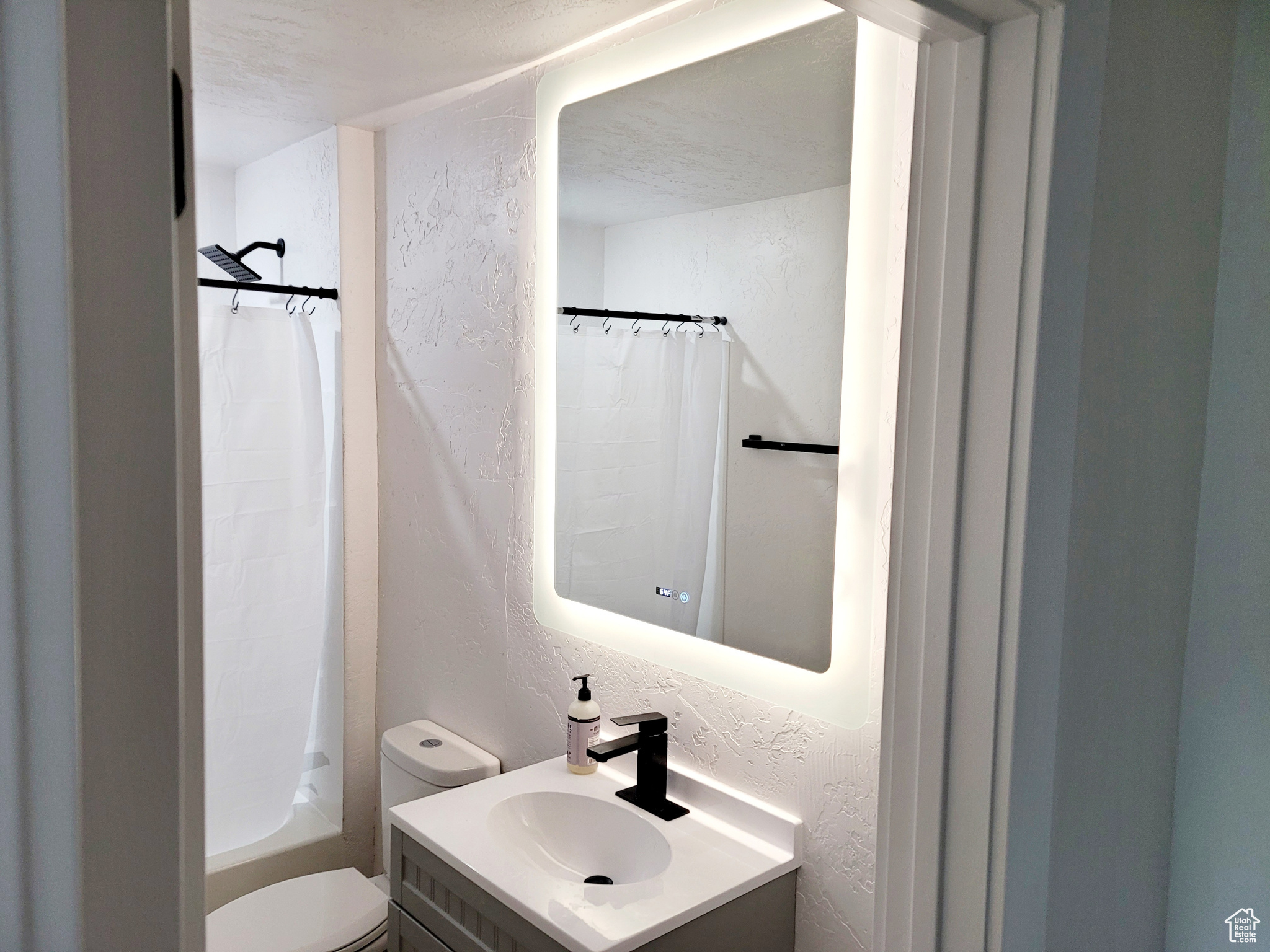 Full bathroom featuring vanity, toilet, and shower / tub combo