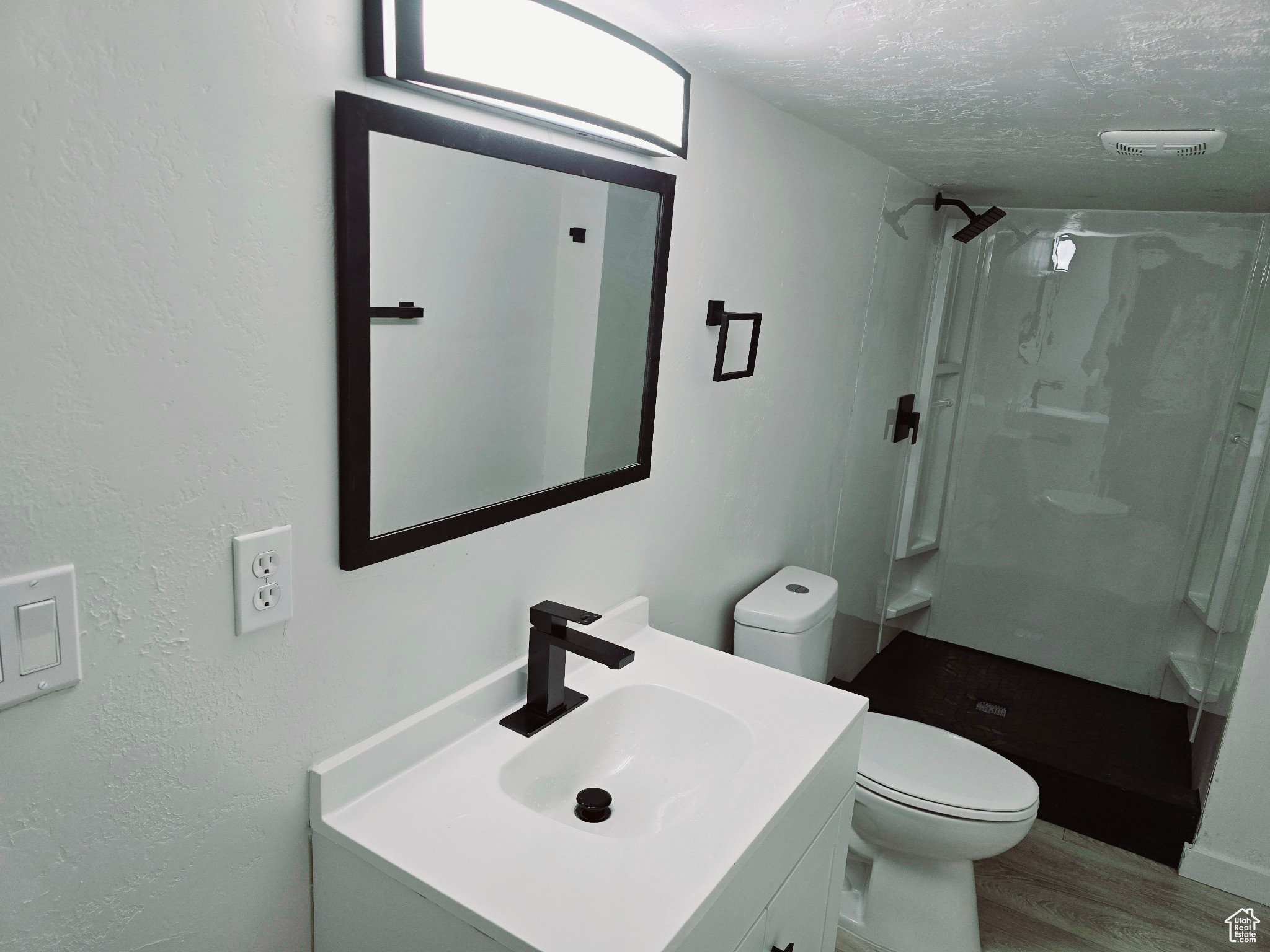 Bathroom featuring walk in shower, toilet, a textured ceiling, vanity, and hardwood / wood-style floors