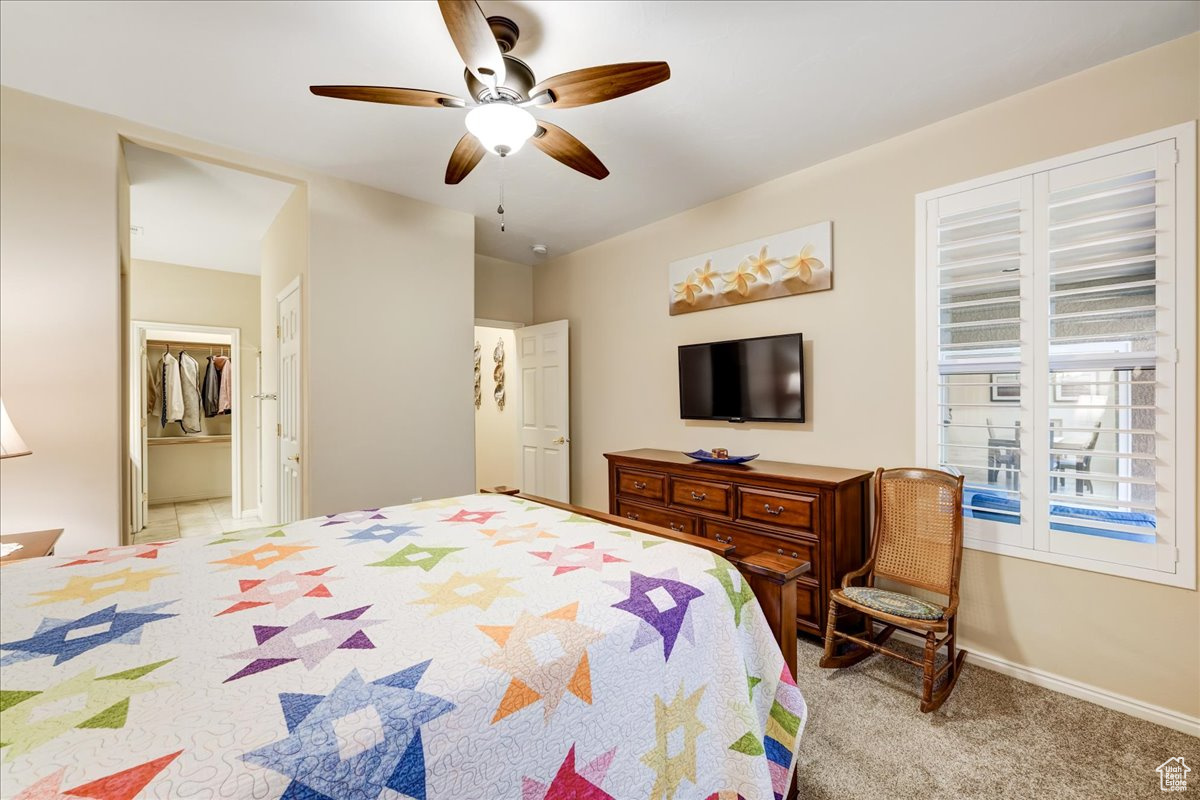 Carpeted bedroom featuring connected bathroom, a closet, and ceiling fan