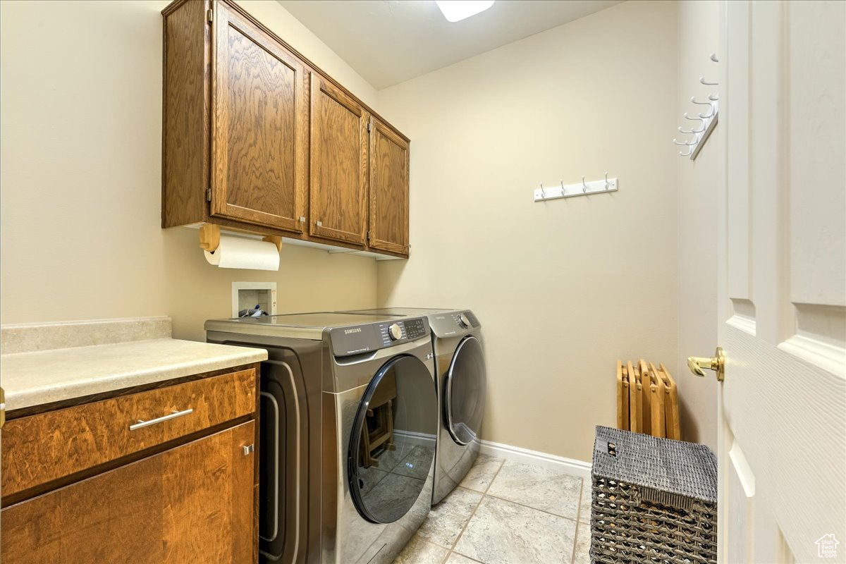 Laundry room with cabinets, radiator, and washer and dryer