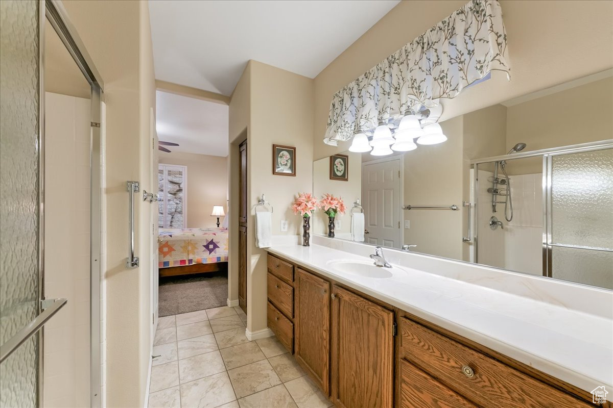 Bathroom with vanity, tile patterned floors, and a shower with shower door