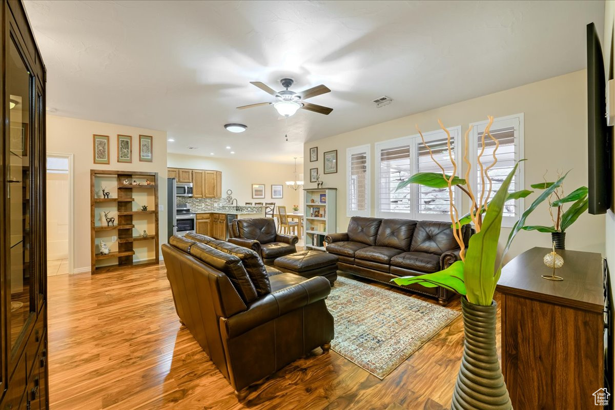 Living room featuring ceiling fan and light wood-type flooring