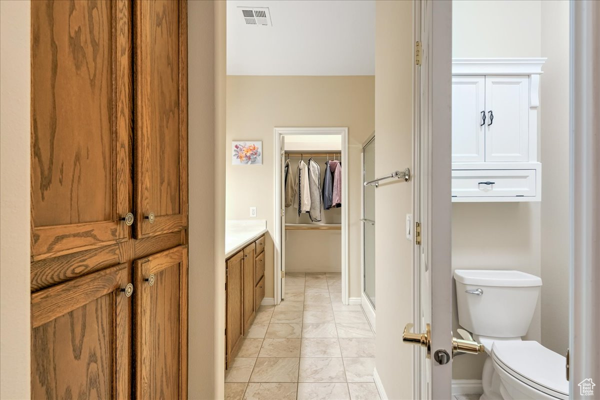 Bathroom featuring vanity, toilet, and a shower with shower door