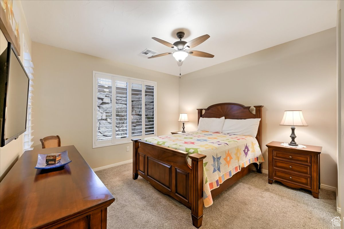 Carpeted bedroom with ceiling fan