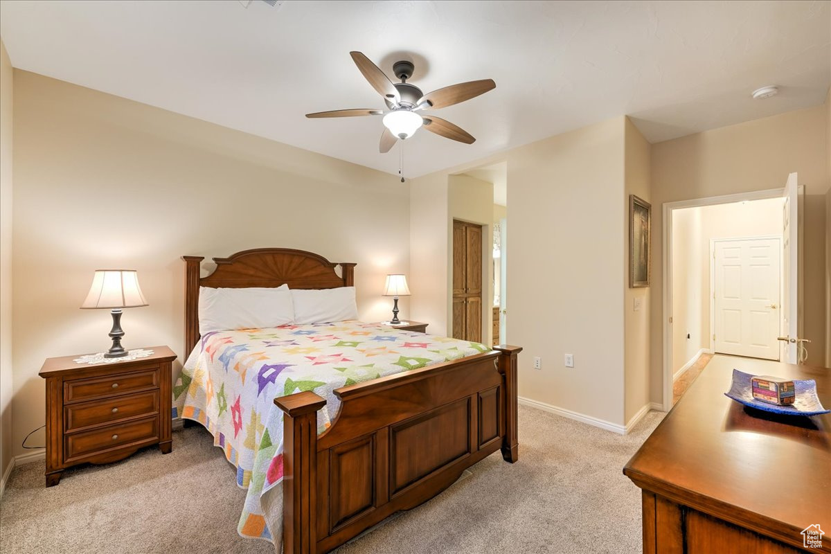 Carpeted bedroom featuring ceiling fan