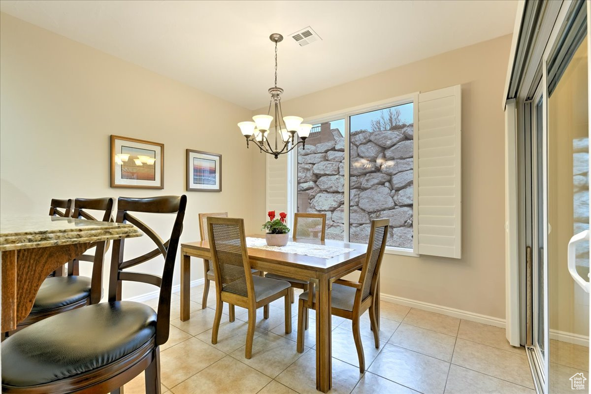 Dining area featuring light tile patterned floors and a chandelier