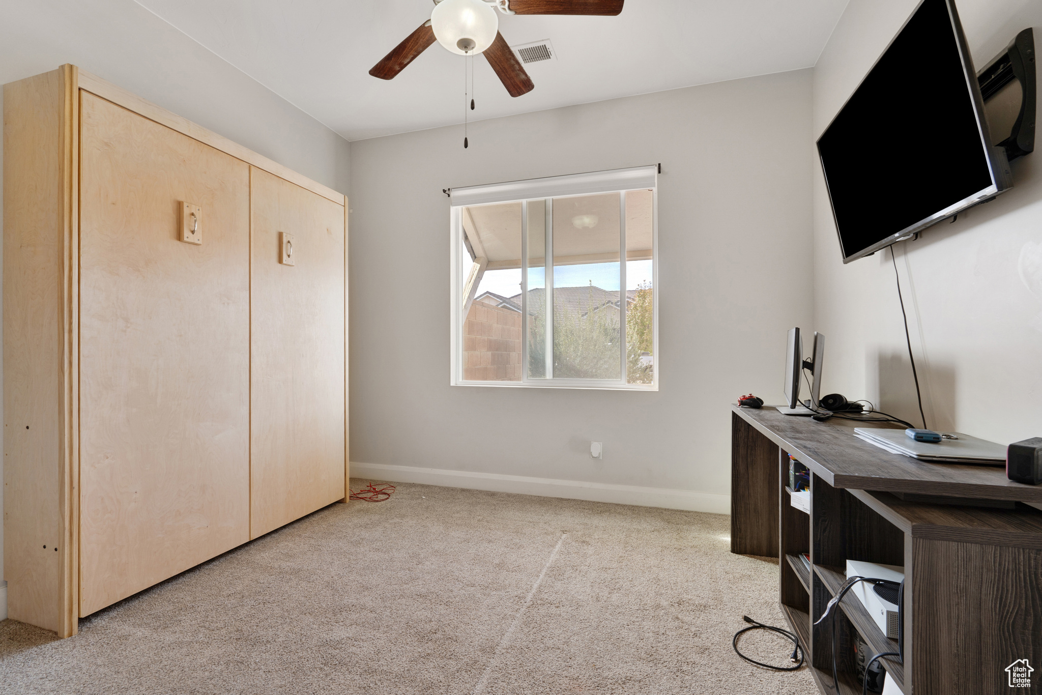 Carpeted office with ceiling fan
