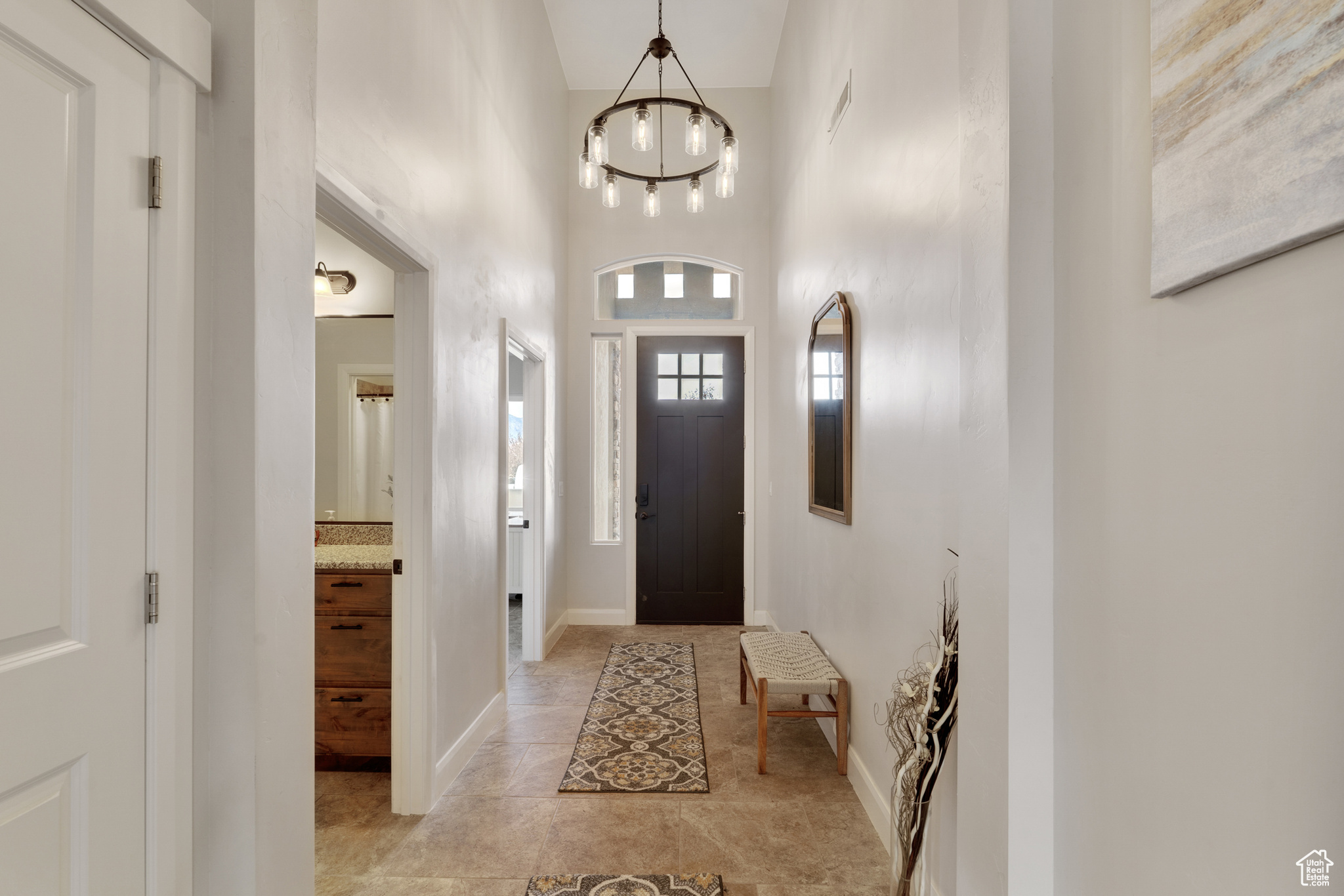 Entryway with a towering ceiling and an inviting chandelier