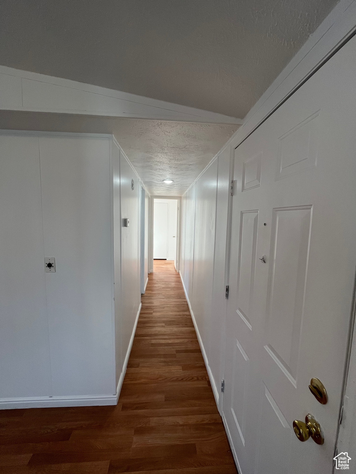 Hall featuring dark hardwood / wood-style floors and a textured ceiling