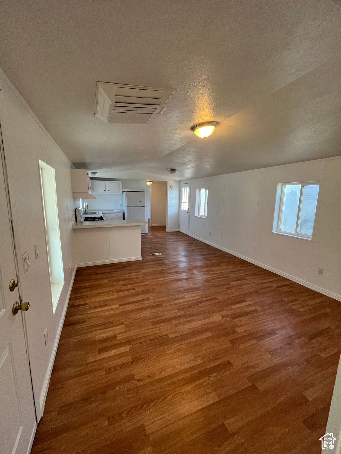 Unfurnished living room with hardwood / wood-style floors and a textured ceiling