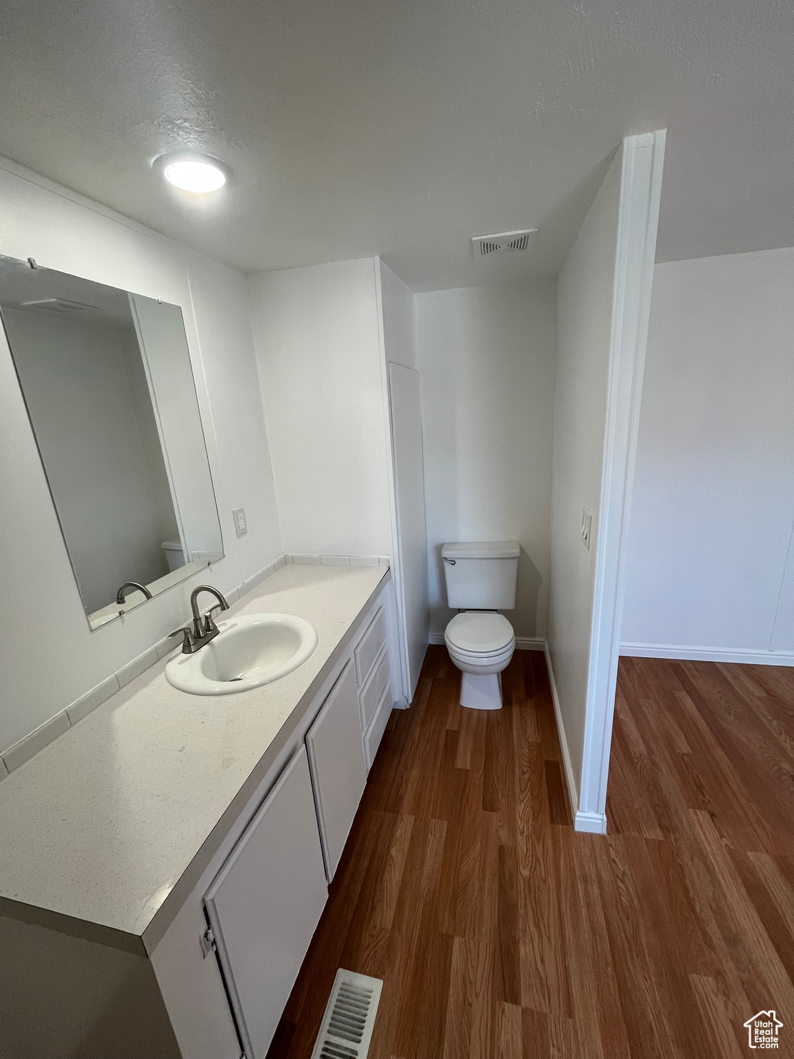 Bathroom featuring vanity, toilet, wood-type flooring, and a textured ceiling