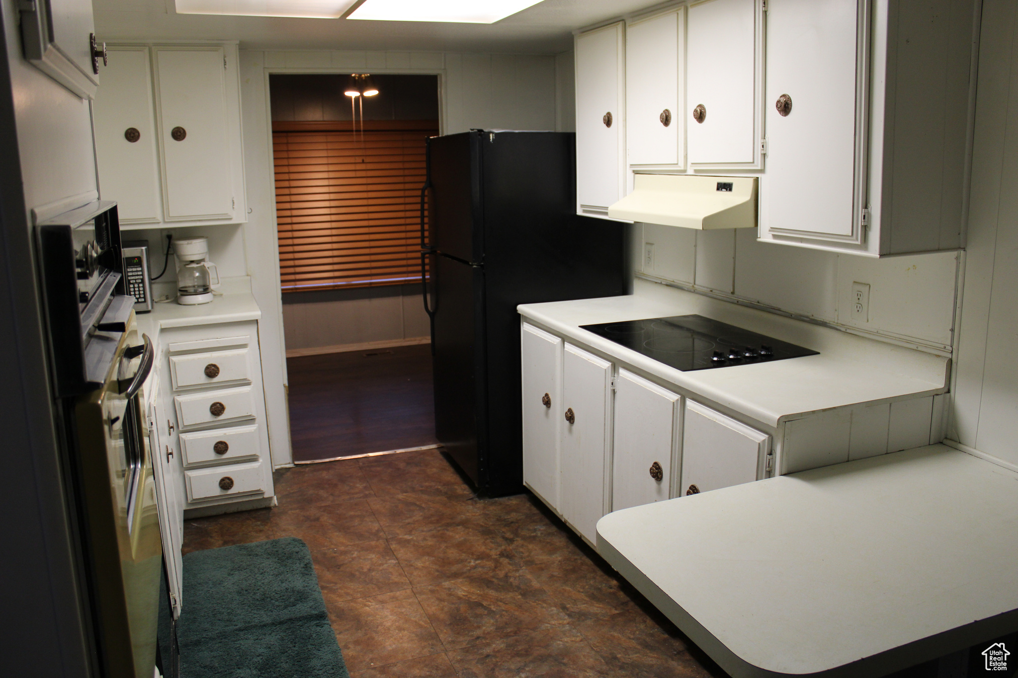 Kitchen featuring white cabinetry and black appliances