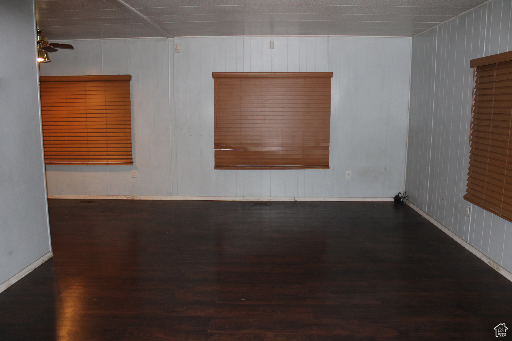 Spare room featuring dark hardwood / wood-style floors and ceiling fan