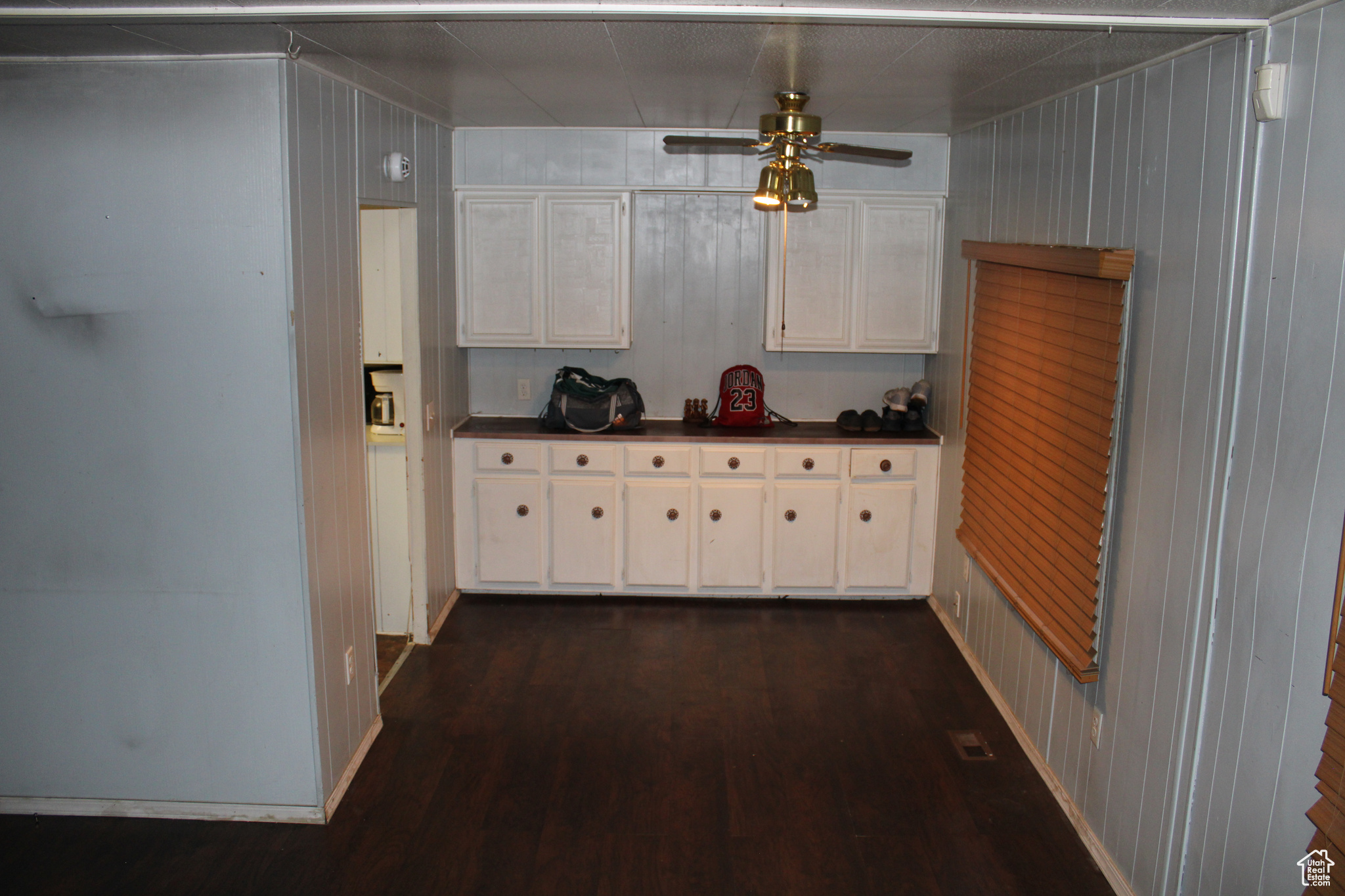 Kitchen featuring ceiling fan, dark hardwood / wood-style flooring, and white cabinetry