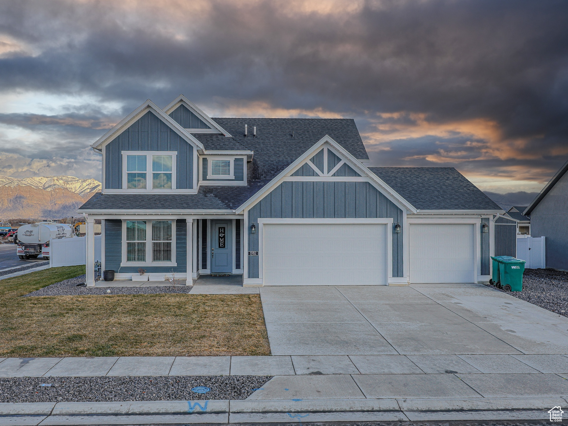 Craftsman-style home featuring a mountain view, a porch, a yard, and a garage