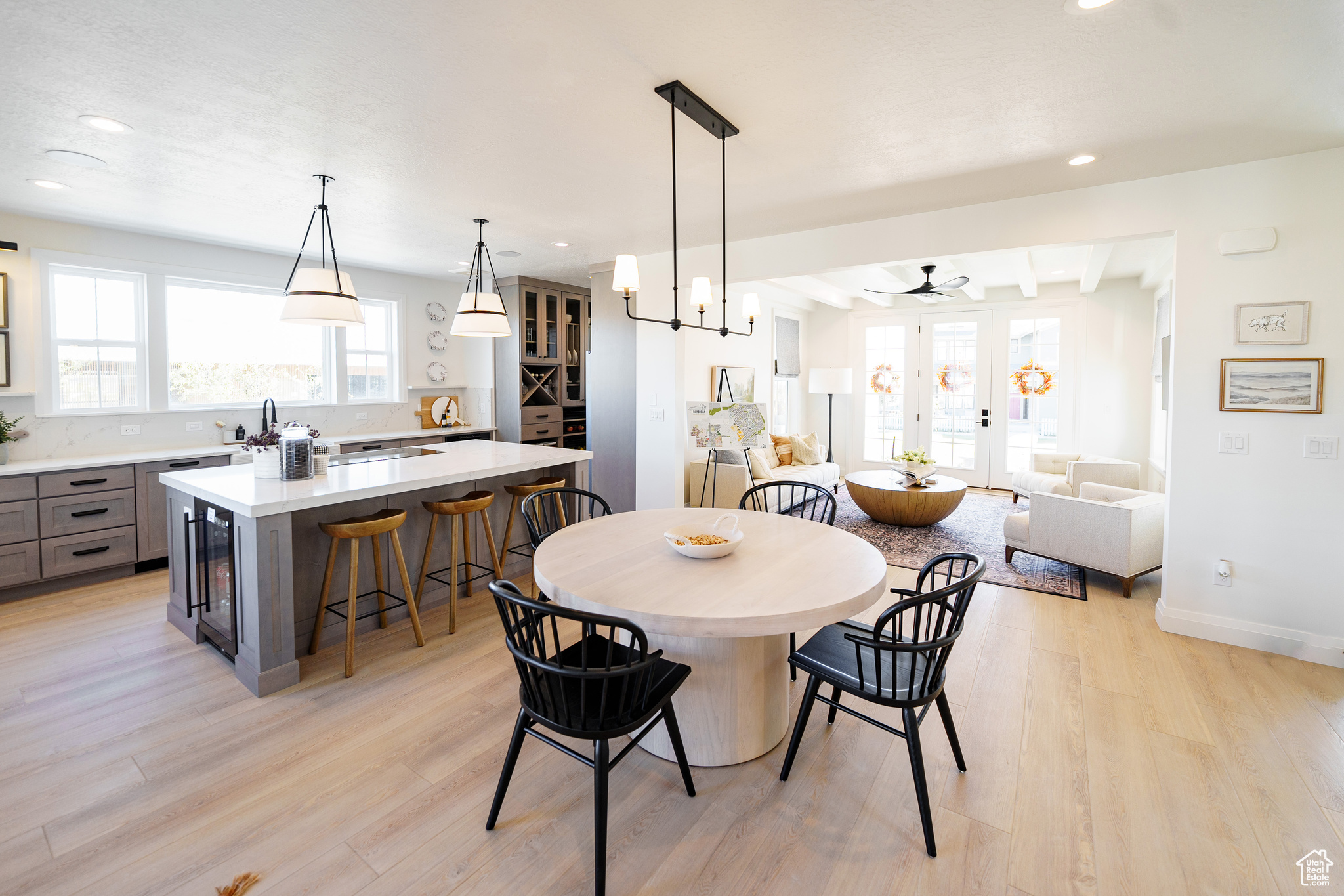 Dining area with wine cooler, ceiling fan, plenty of natural light, and light wood-type flooring