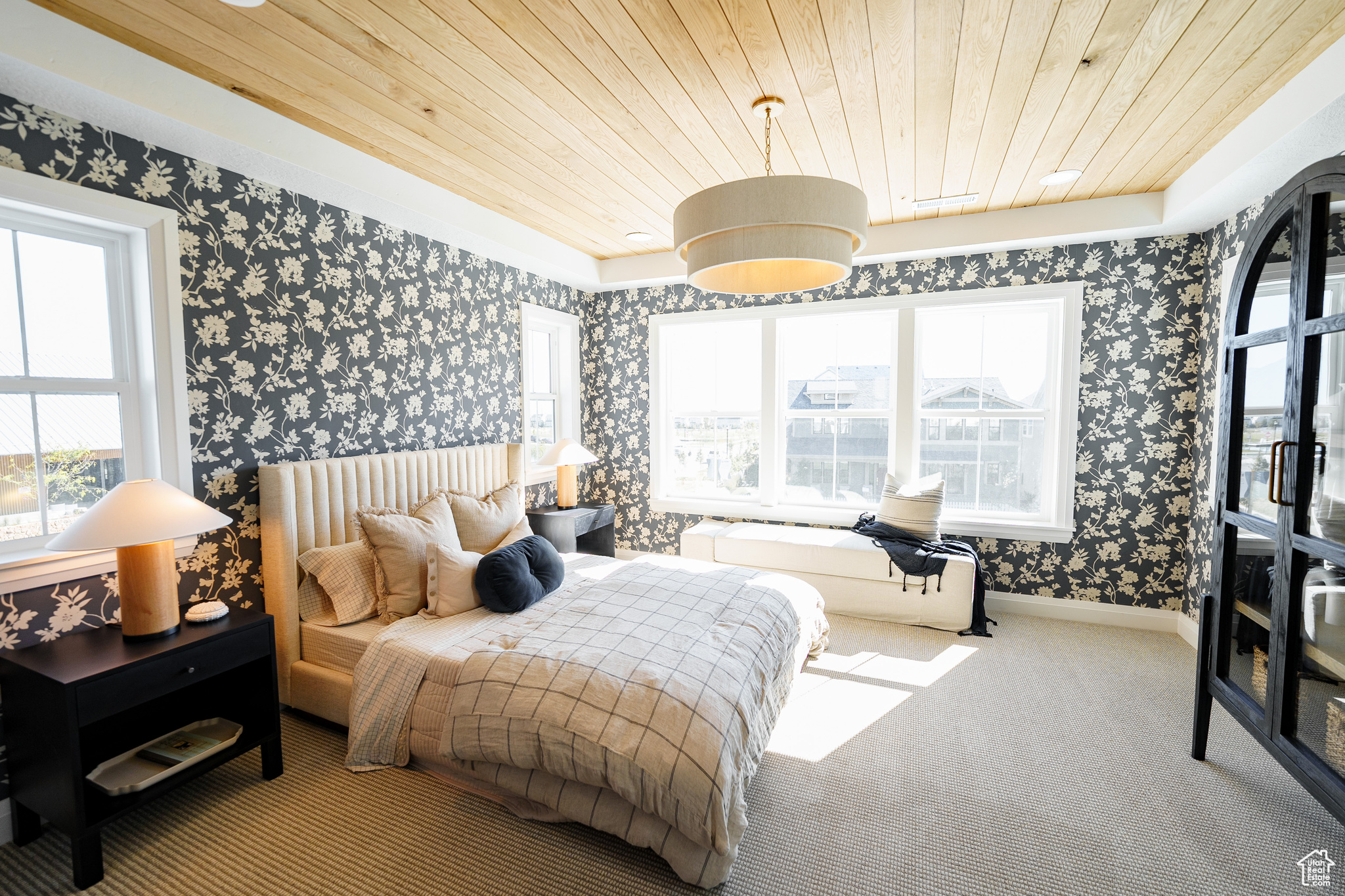 Bedroom featuring carpet, wood ceiling, and multiple windows