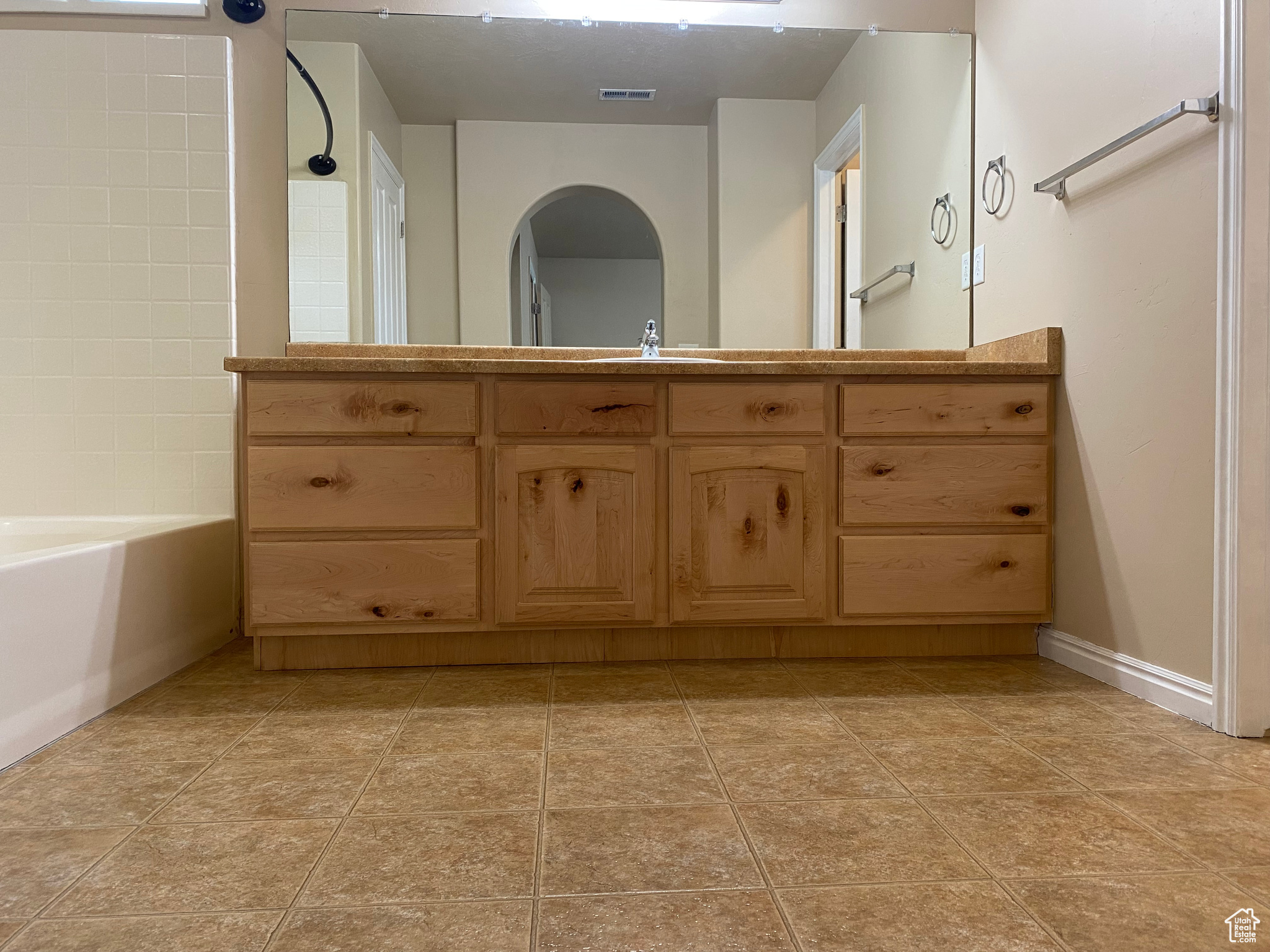 Bathroom with sink, bathtub / shower combination, and tile patterned flooring