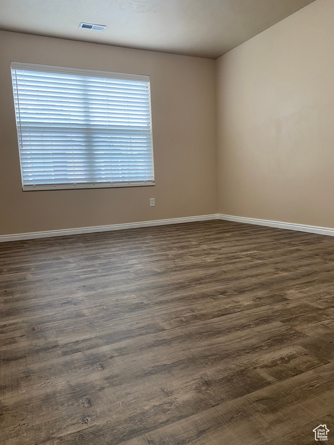 Empty room featuring dark hardwood / wood-style floors