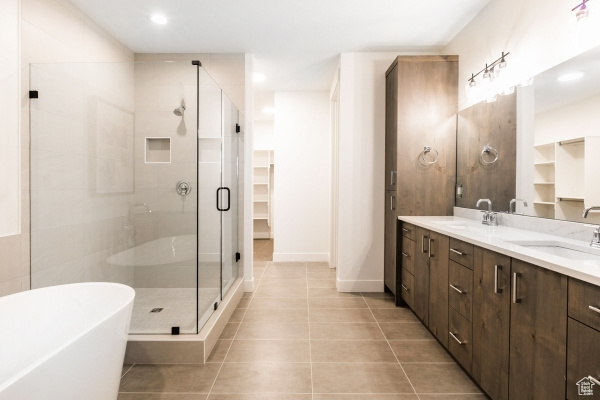 Bathroom featuring tile patterned floors, separate shower and tub, and vanity