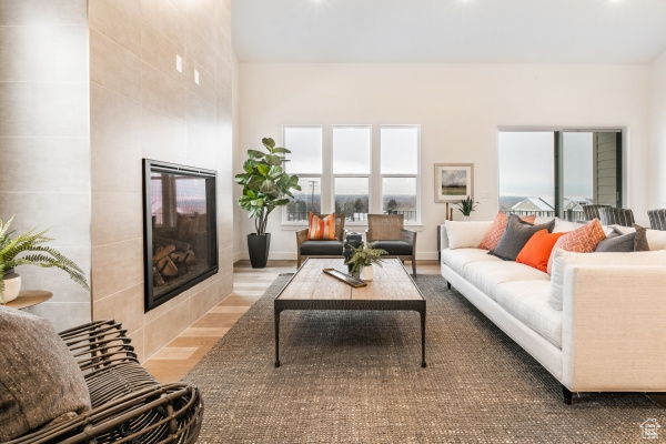 Living room featuring a tiled fireplace and wood-type flooring