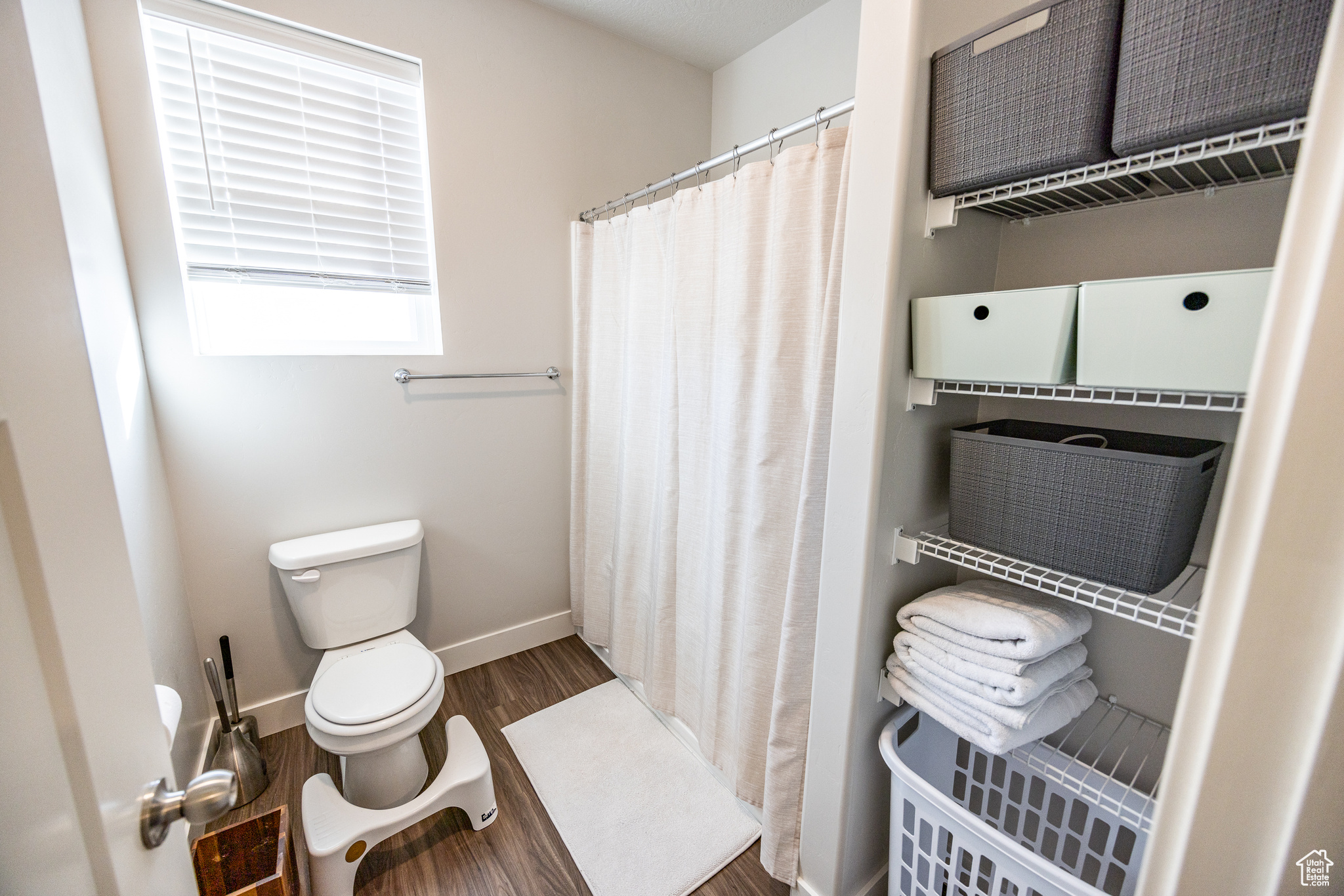 Bathroom featuring hardwood / wood-style floors, a shower with curtain, and toilet