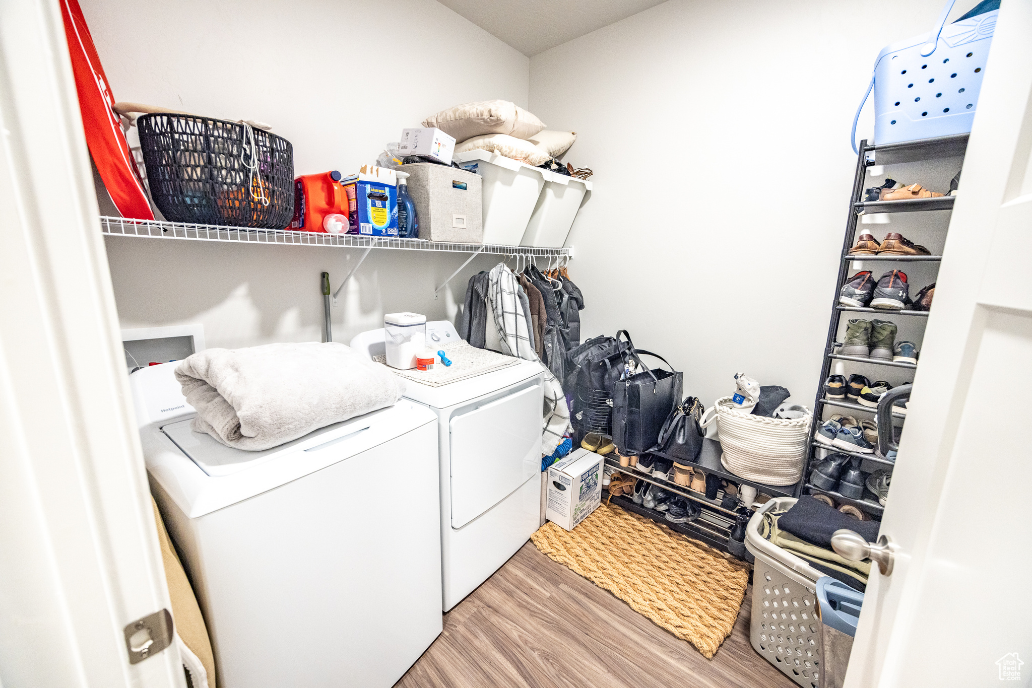 Clothes washing area with washer and dryer and light wood-type flooring