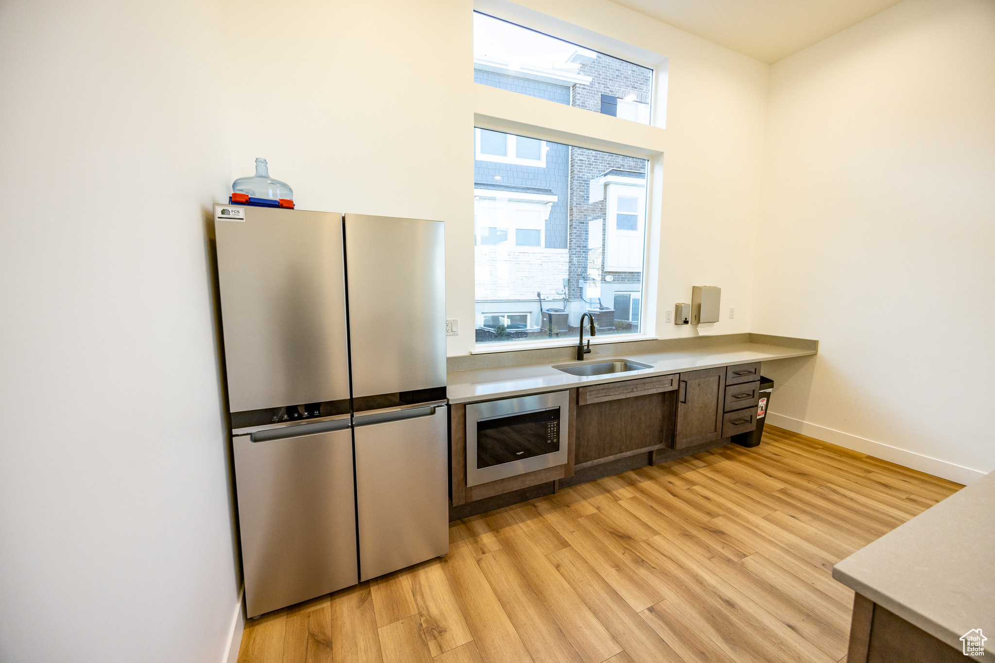 Kitchen with light wood-type flooring, stainless steel appliances, and sink