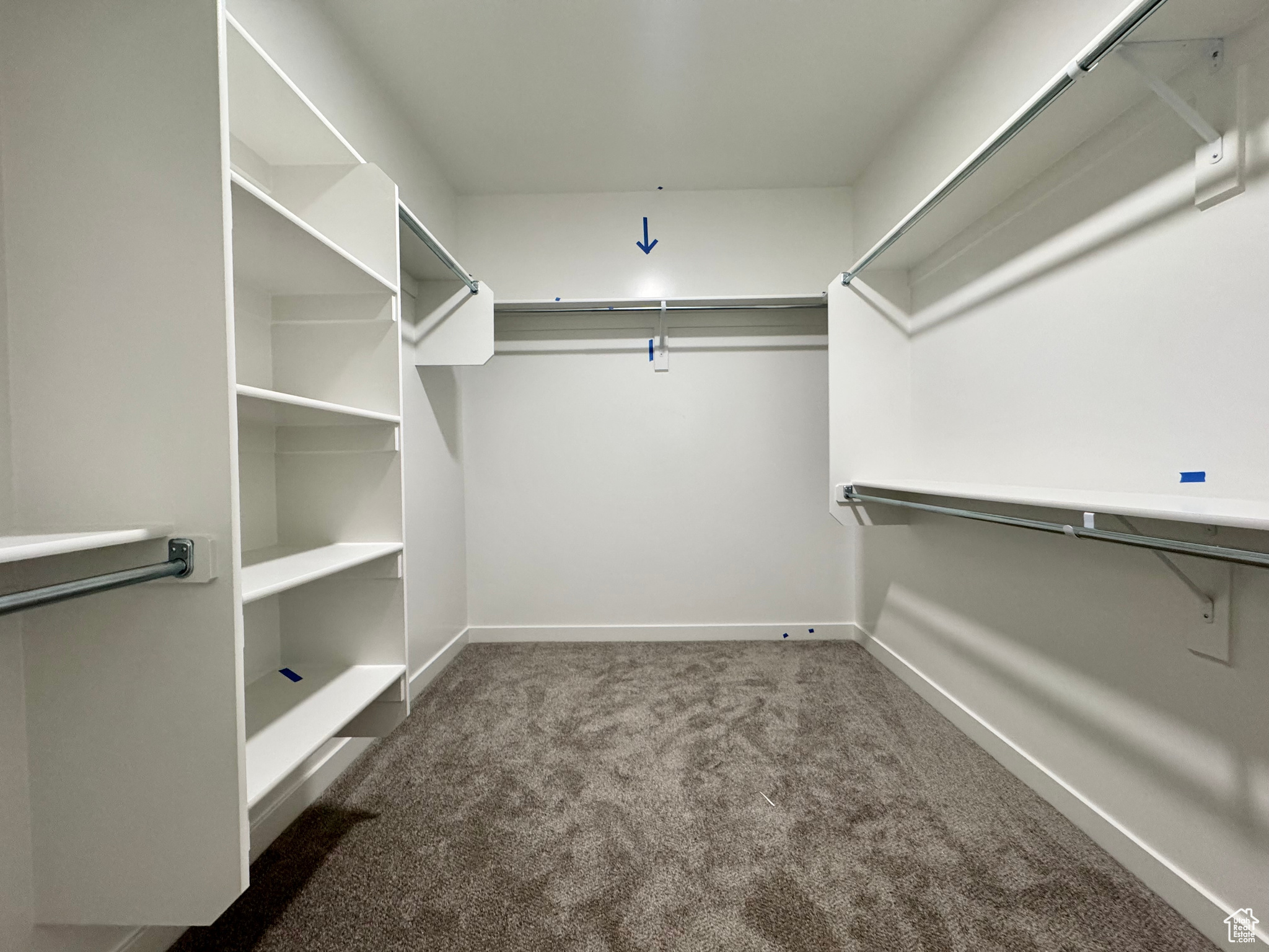 Spacious closet with dark colored carpet