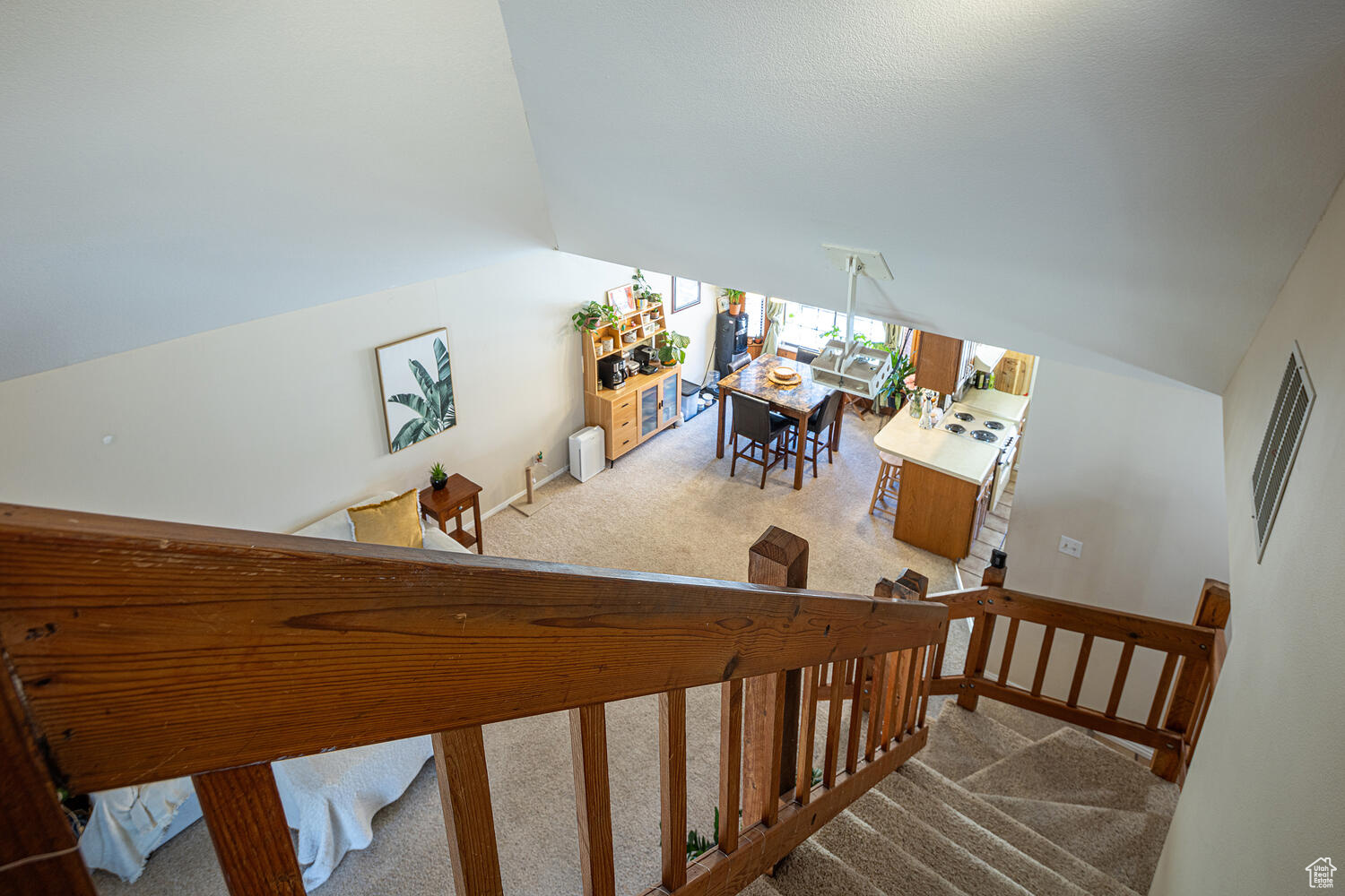 Stairway with carpet and lofted ceiling