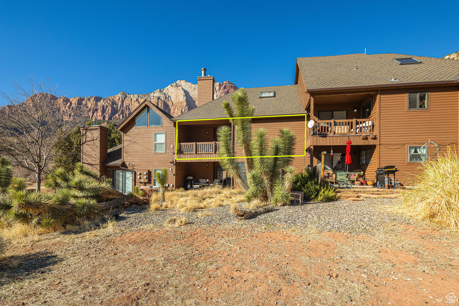 Back of house with a mountain view and a balcony