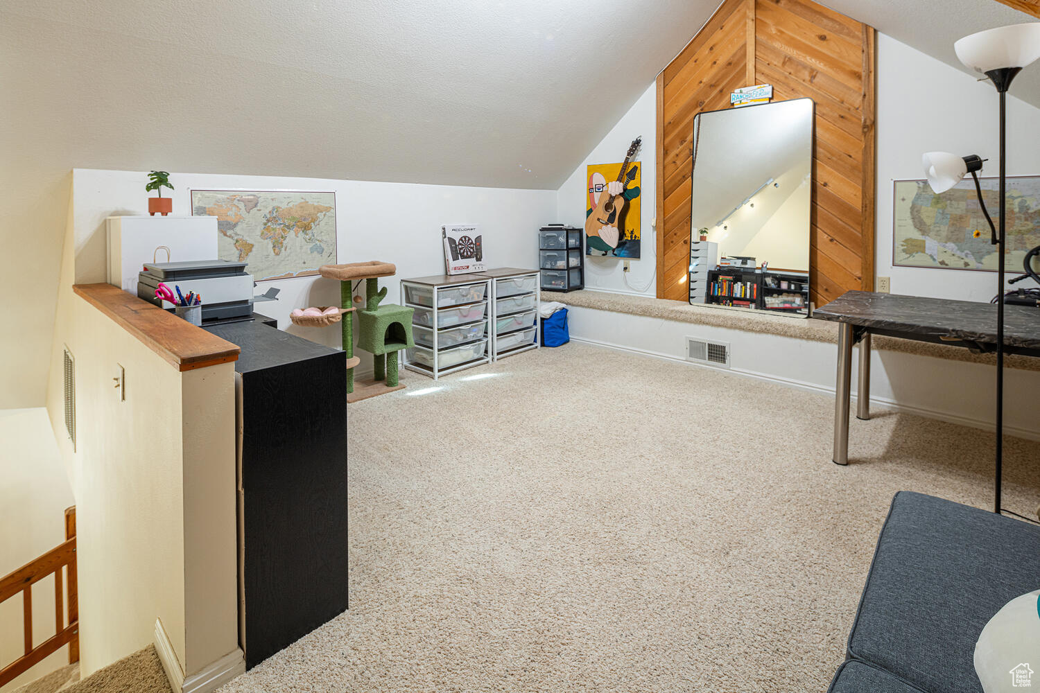 Carpeted home office with lofted ceiling