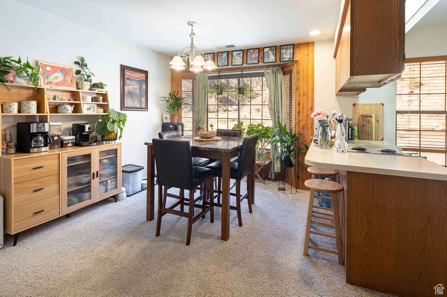 Carpeted dining room featuring a notable chandelier