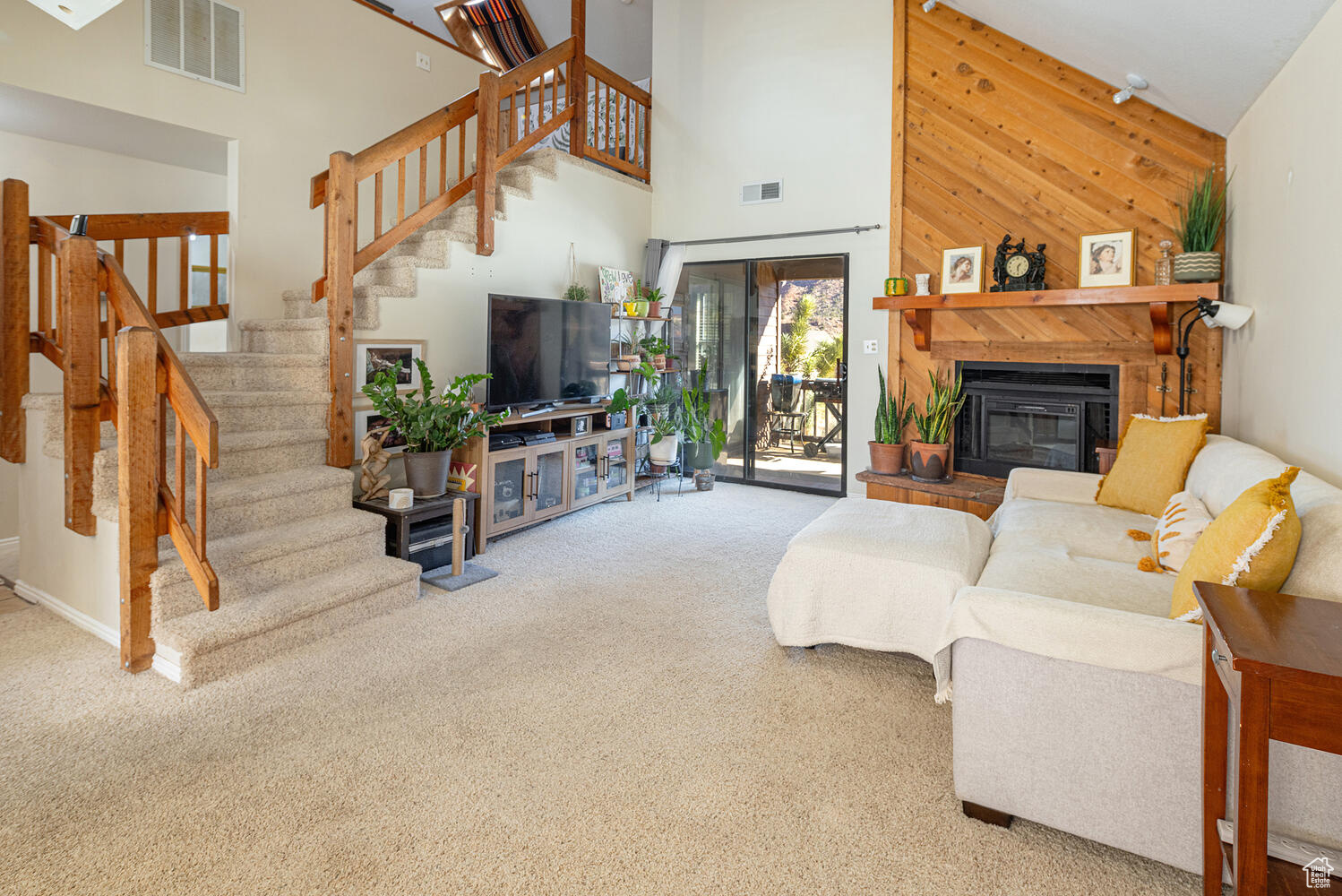 Carpeted living room with high vaulted ceiling