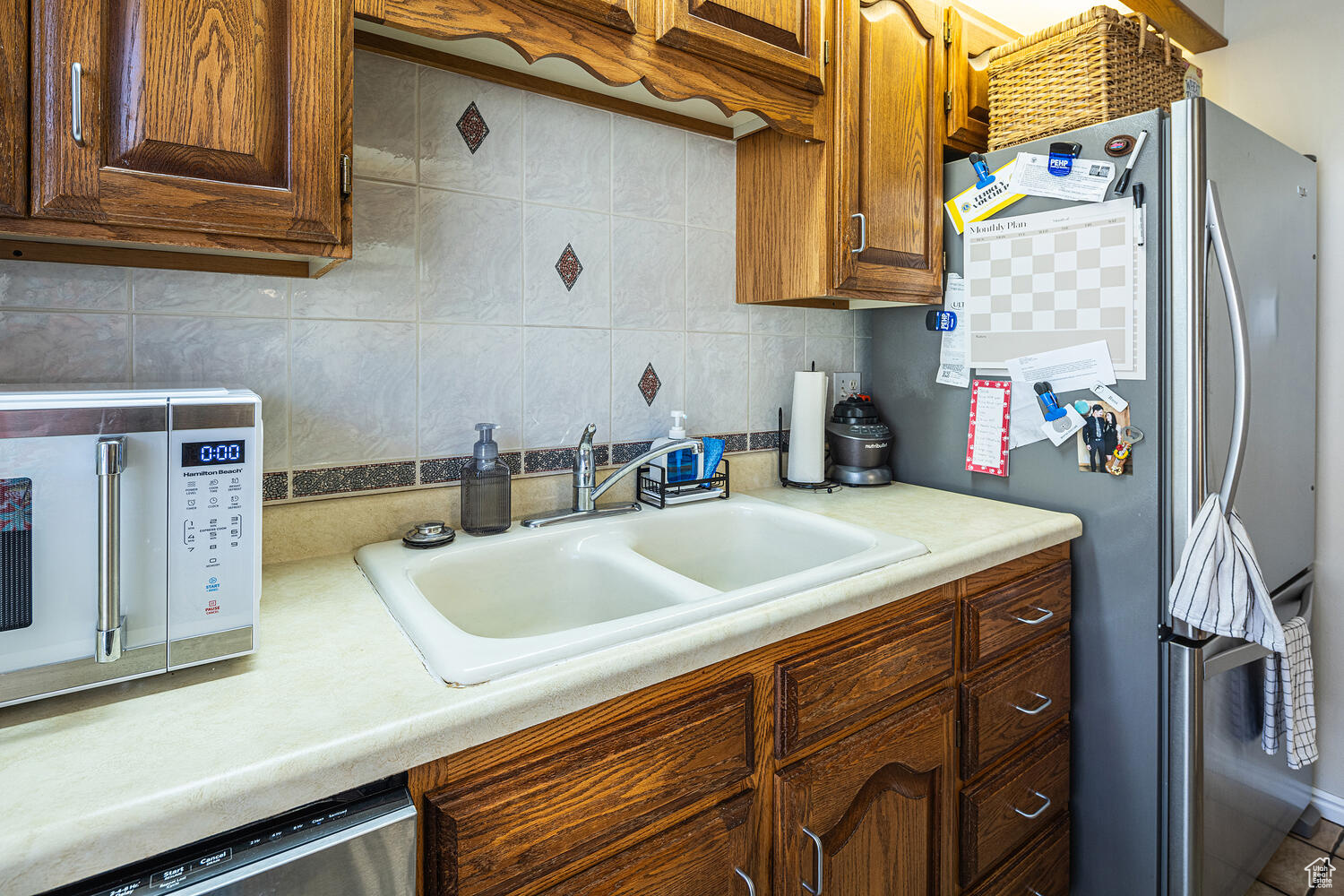 Kitchen with appliances with stainless steel finishes, backsplash, and sink