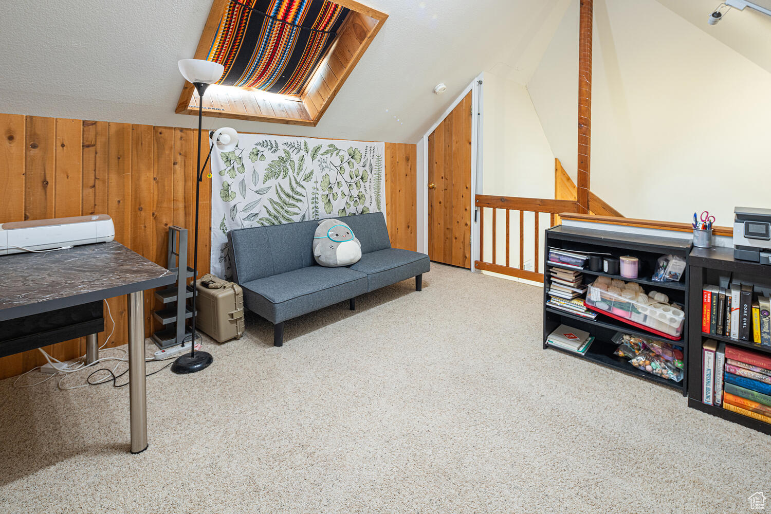 Sitting room with wooden walls, carpet, and lofted ceiling