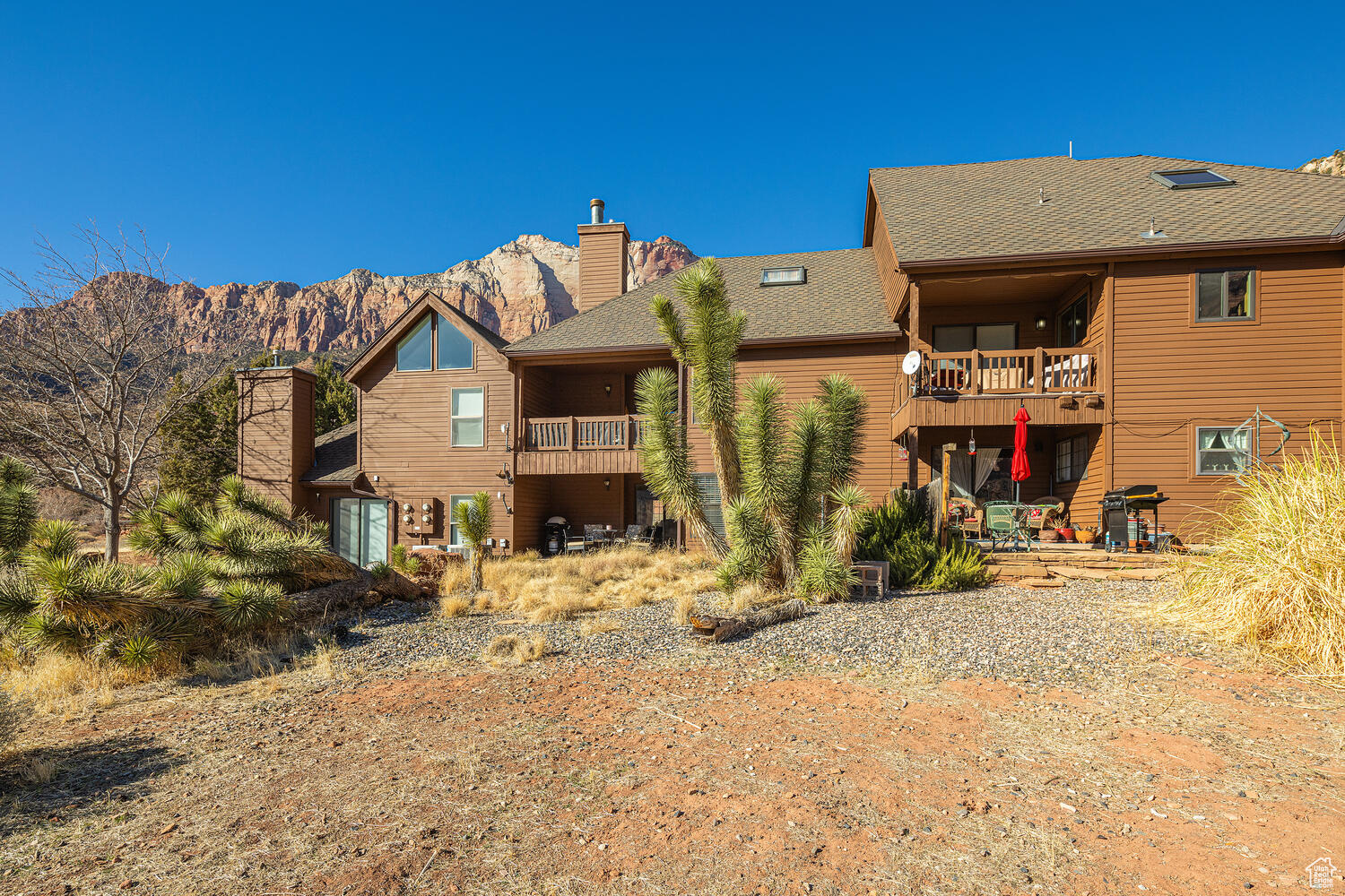 Rear view of property with a mountain view and a balcony